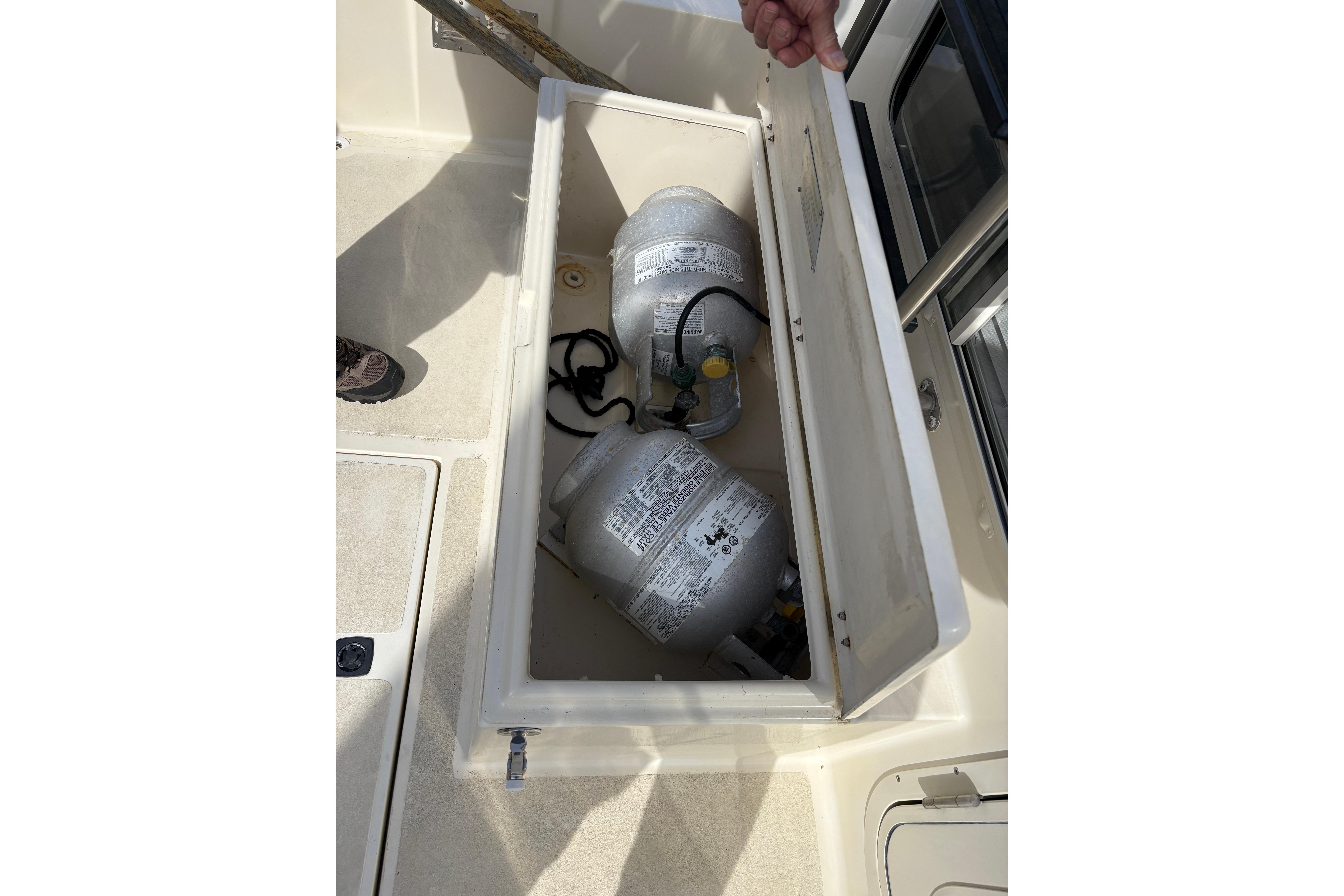 Open storage compartment on 2004 Nordic Tug 32 with propane tanks inside.