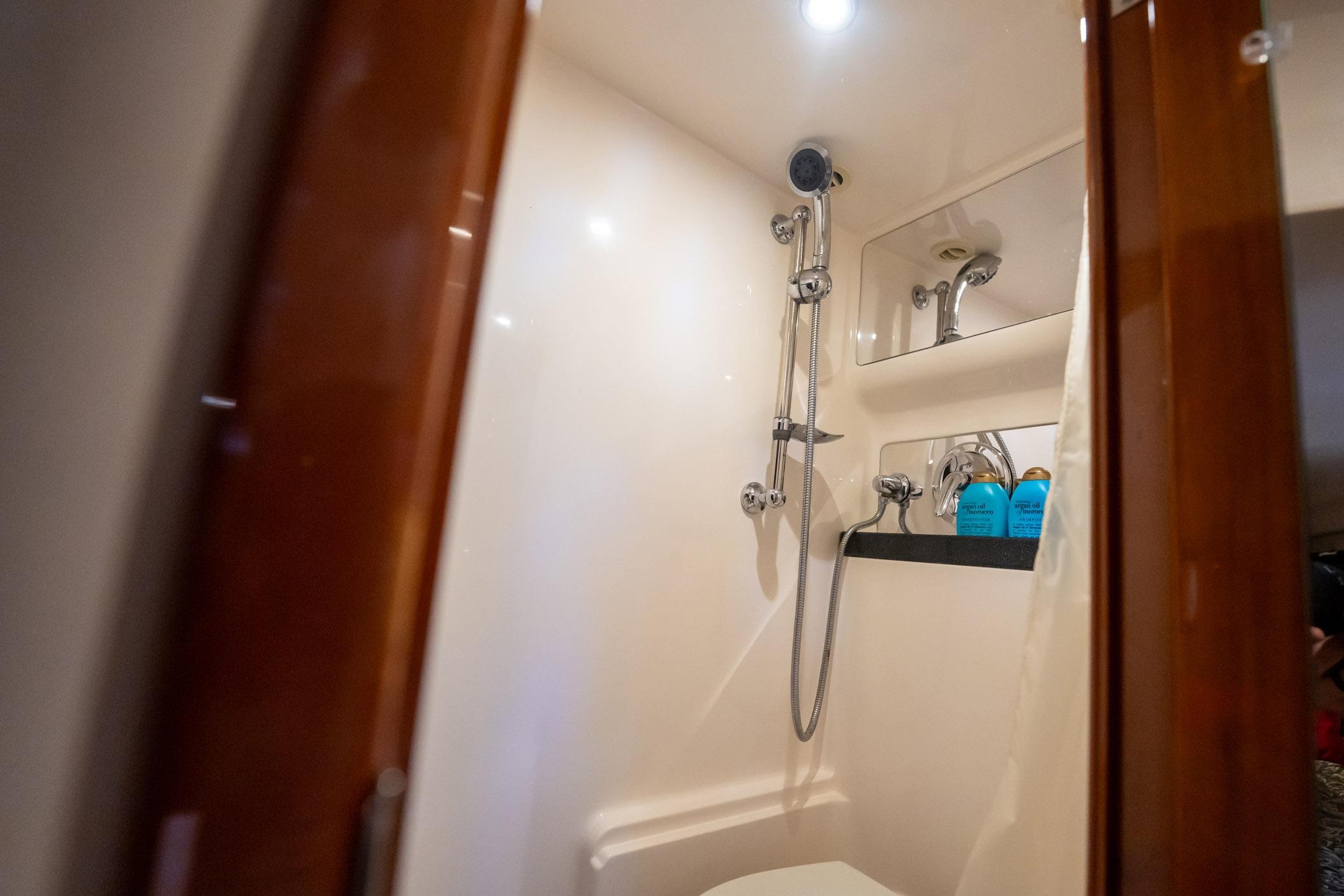 Luxurious bathroom in 2008 Regal Commodore 4460 yacht with shower and toiletries.
