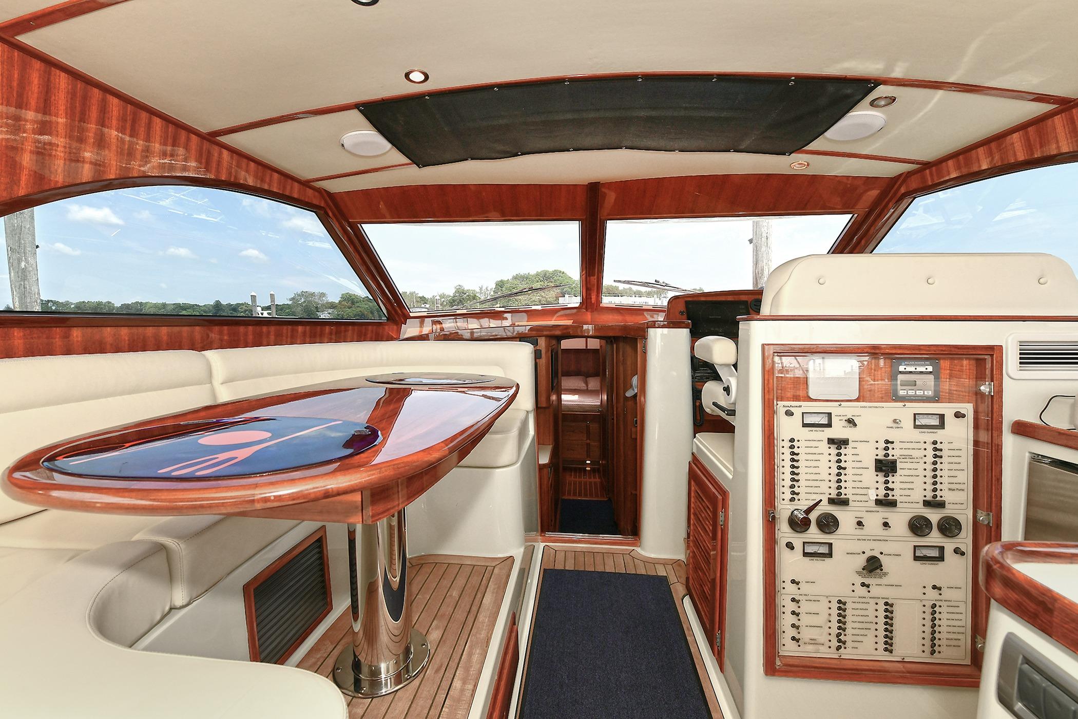 Luxurious 2005 San Juan Downeast Express yacht interior with elegant wood finishes and control panel.