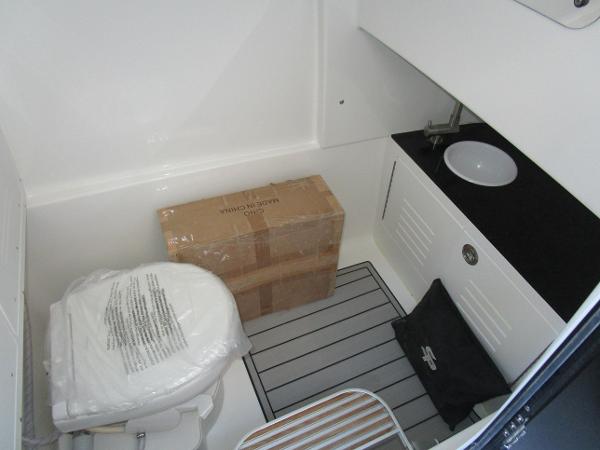 2025 Sea Pro 292 Offshore boat bathroom with toilet, sink, and storage cabinet.