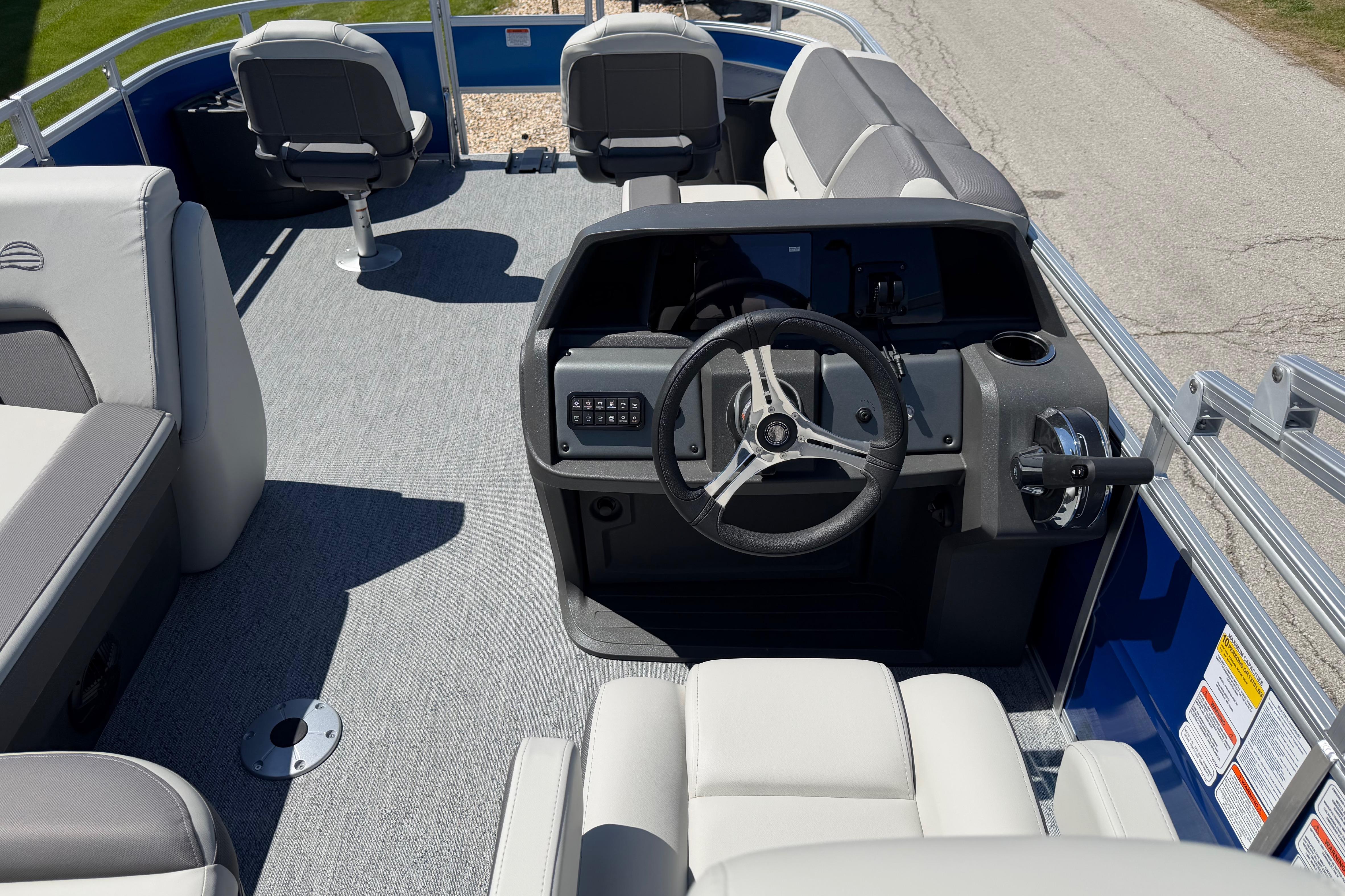 2026 Sun Tracker Fishin' Barge 20 DLX interior with steering wheel and seating.