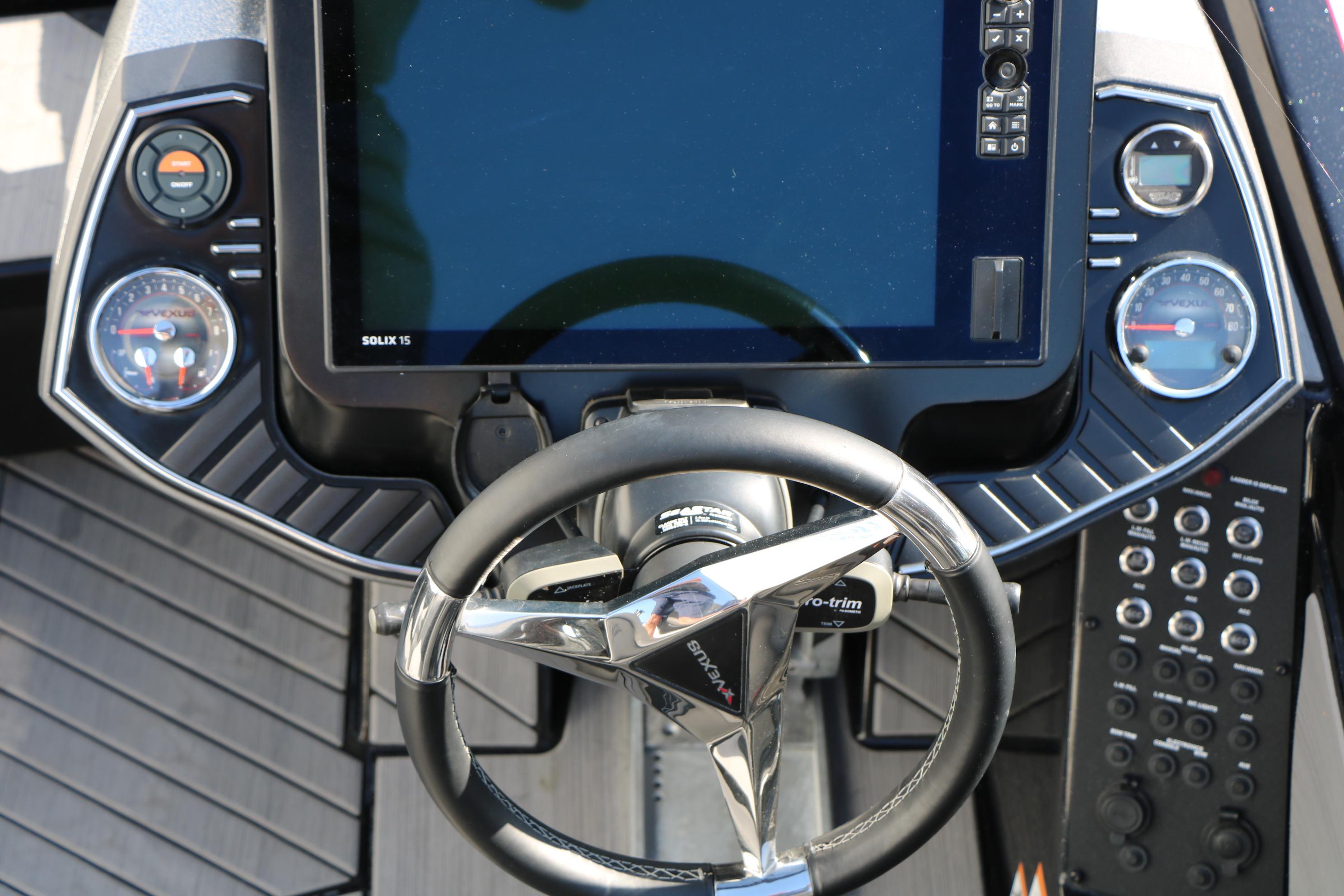 2022 Vexus VX21 boat dashboard with steering wheel and digital display.