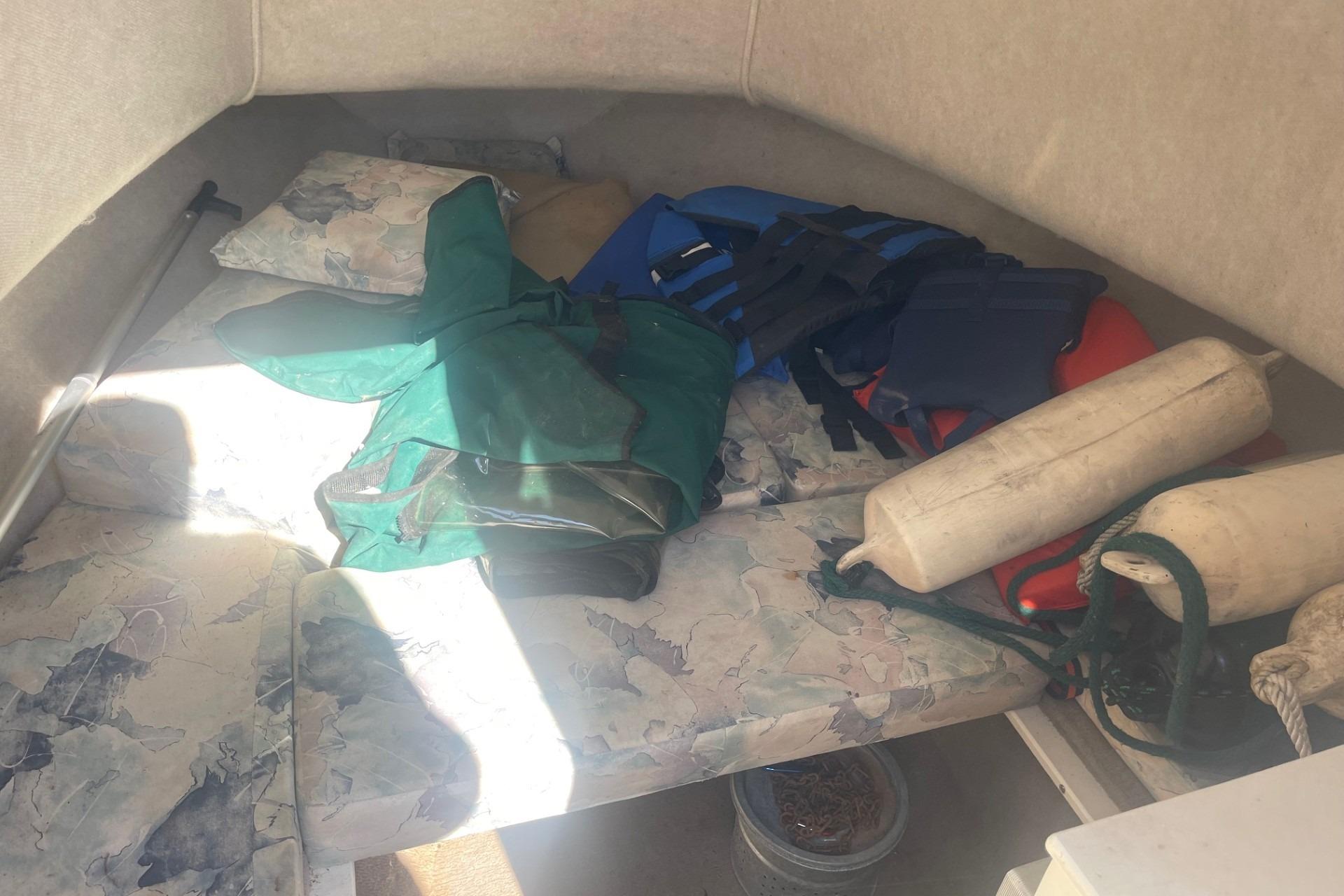 Interior of a 2000 Seamaster 2388 WA boat with life jackets and fenders.