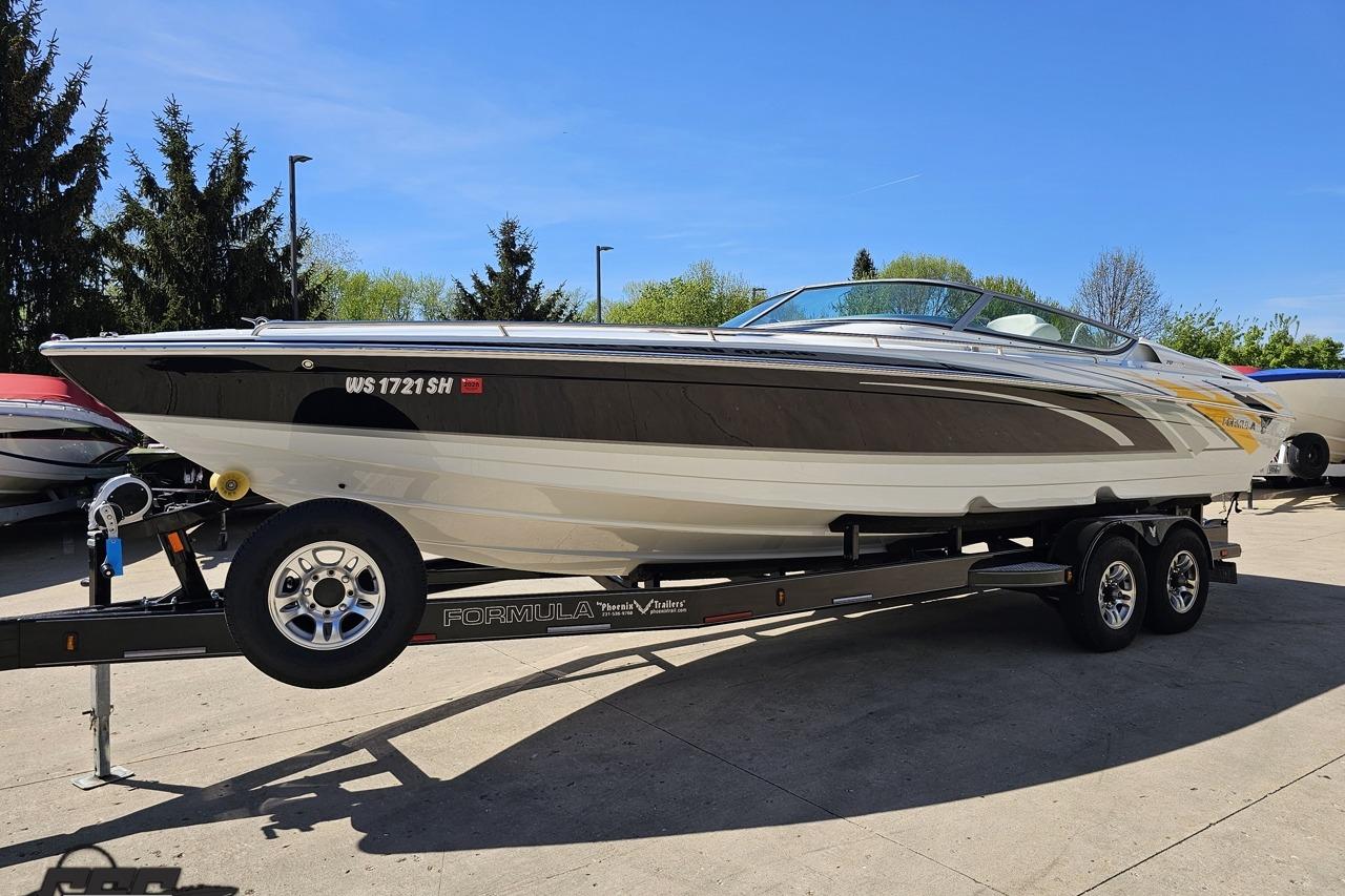 2014 Formula 292 FASTech boat on trailer, parked outdoors under clear blue sky.