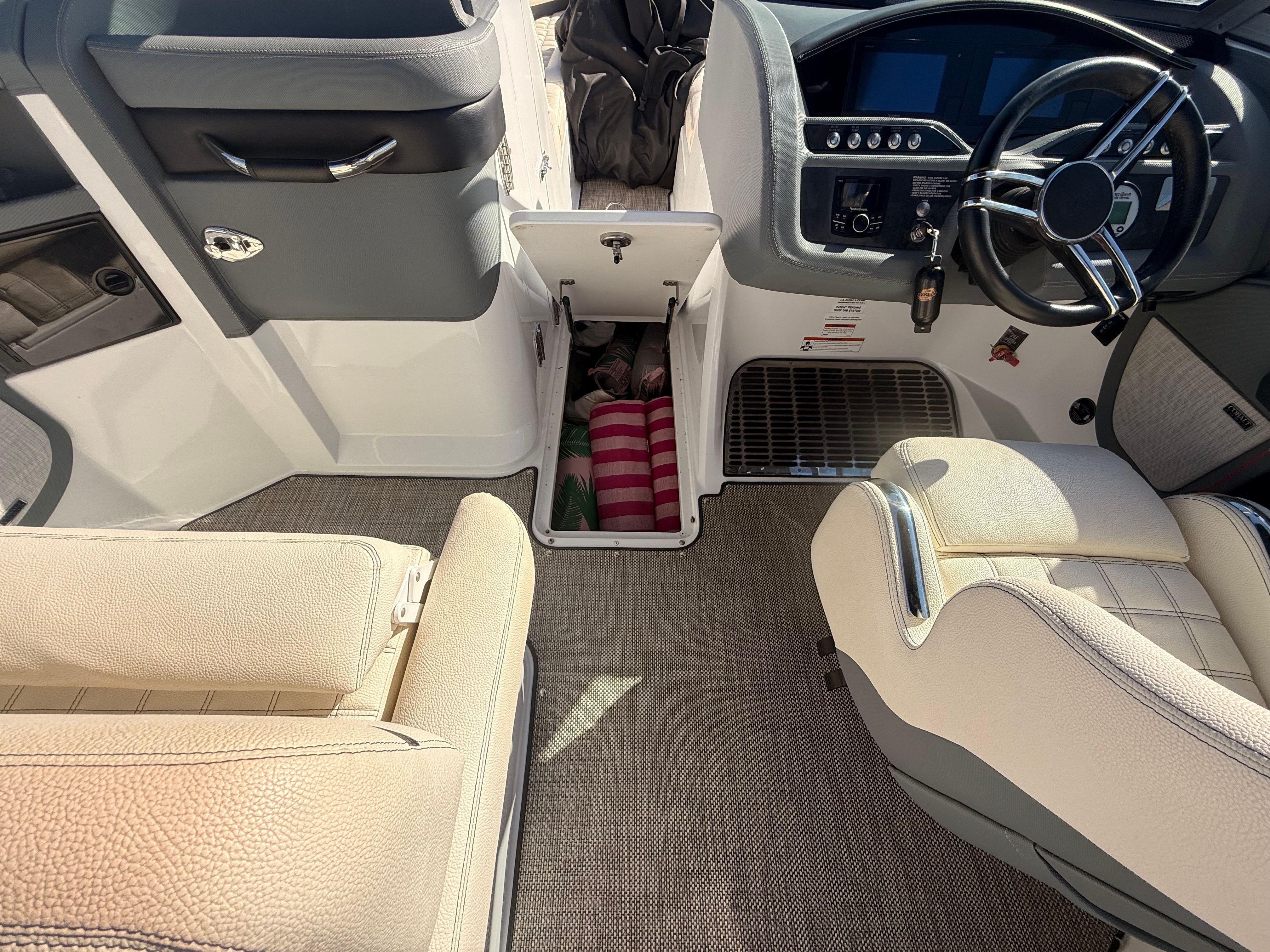 The image shows the cockpit of a 2019 Cobalt R7 Surf boat with beige seats and a modern dashboard.