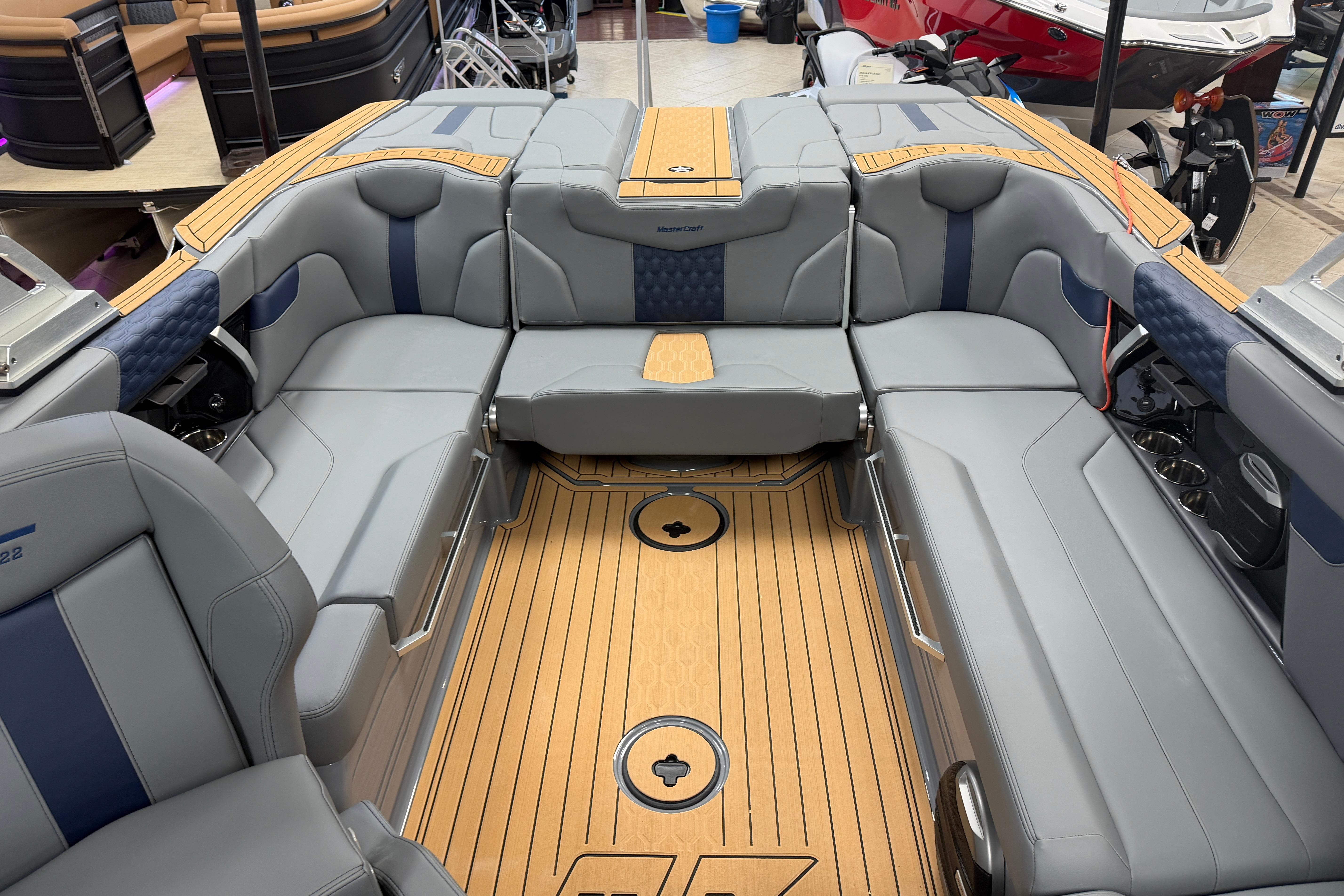 2026 MasterCraft XT22 boat interior with luxurious gray seating and teak flooring.