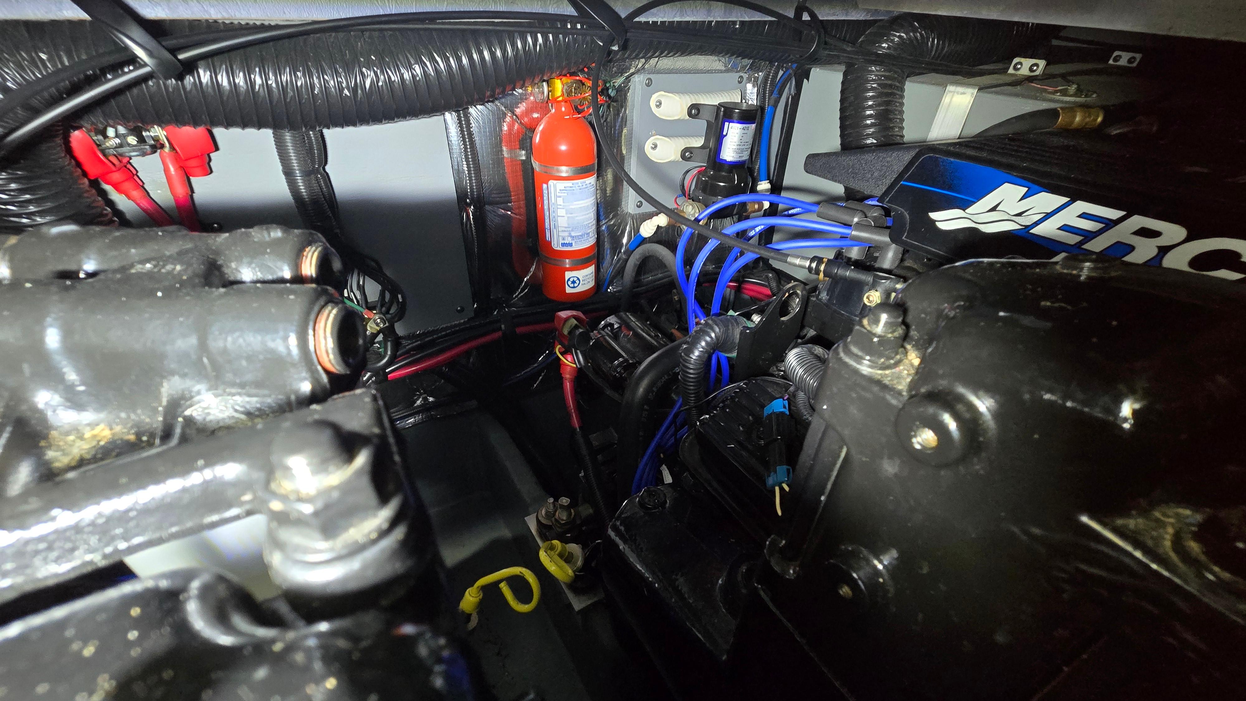 Engine compartment of a 2000 Sea Ray 310 Sundancer with visible fire extinguisher and wiring.