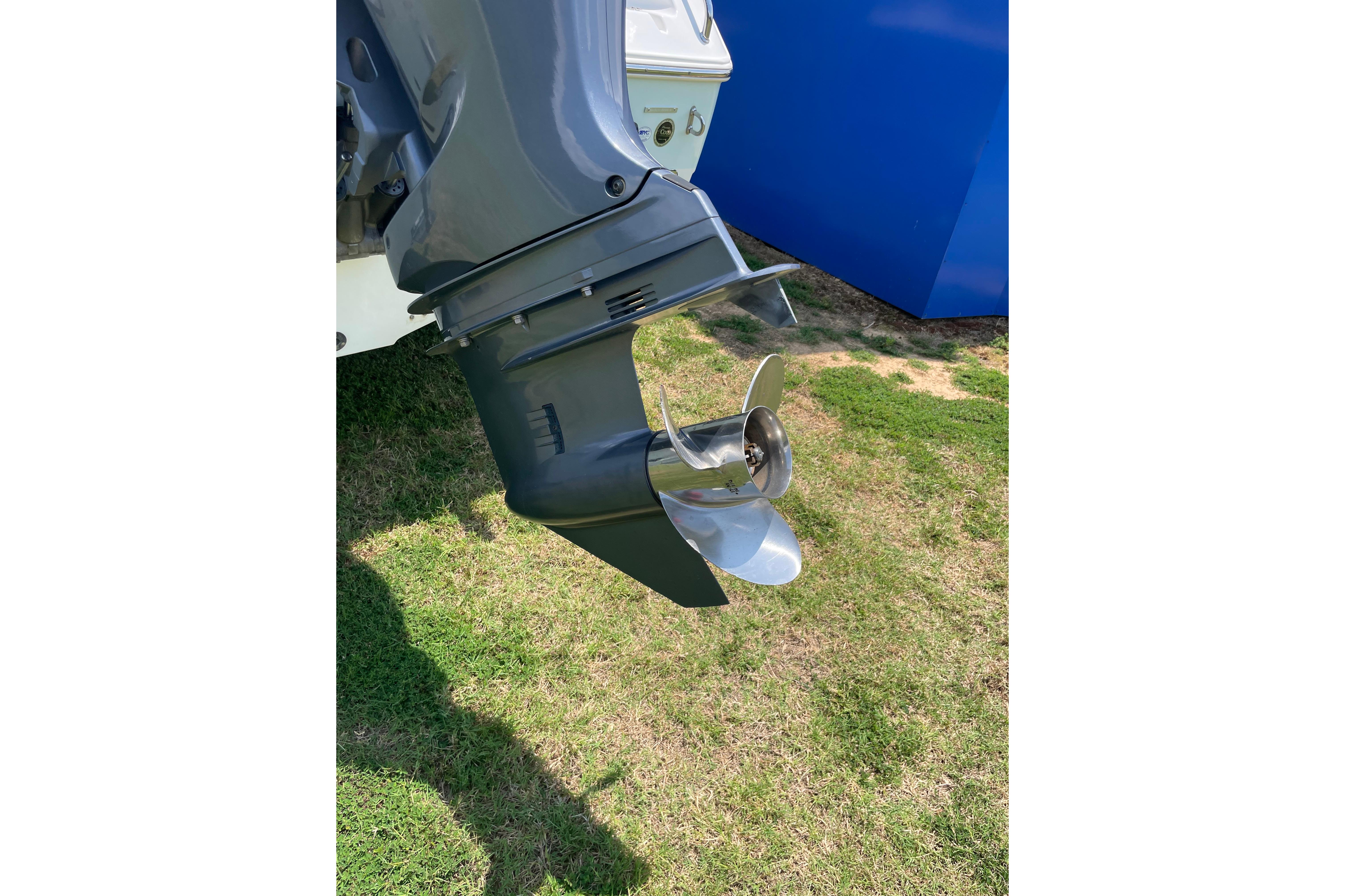 Outboard motor of 2018 Sea Hunt Ultra 234 boat on grass.
