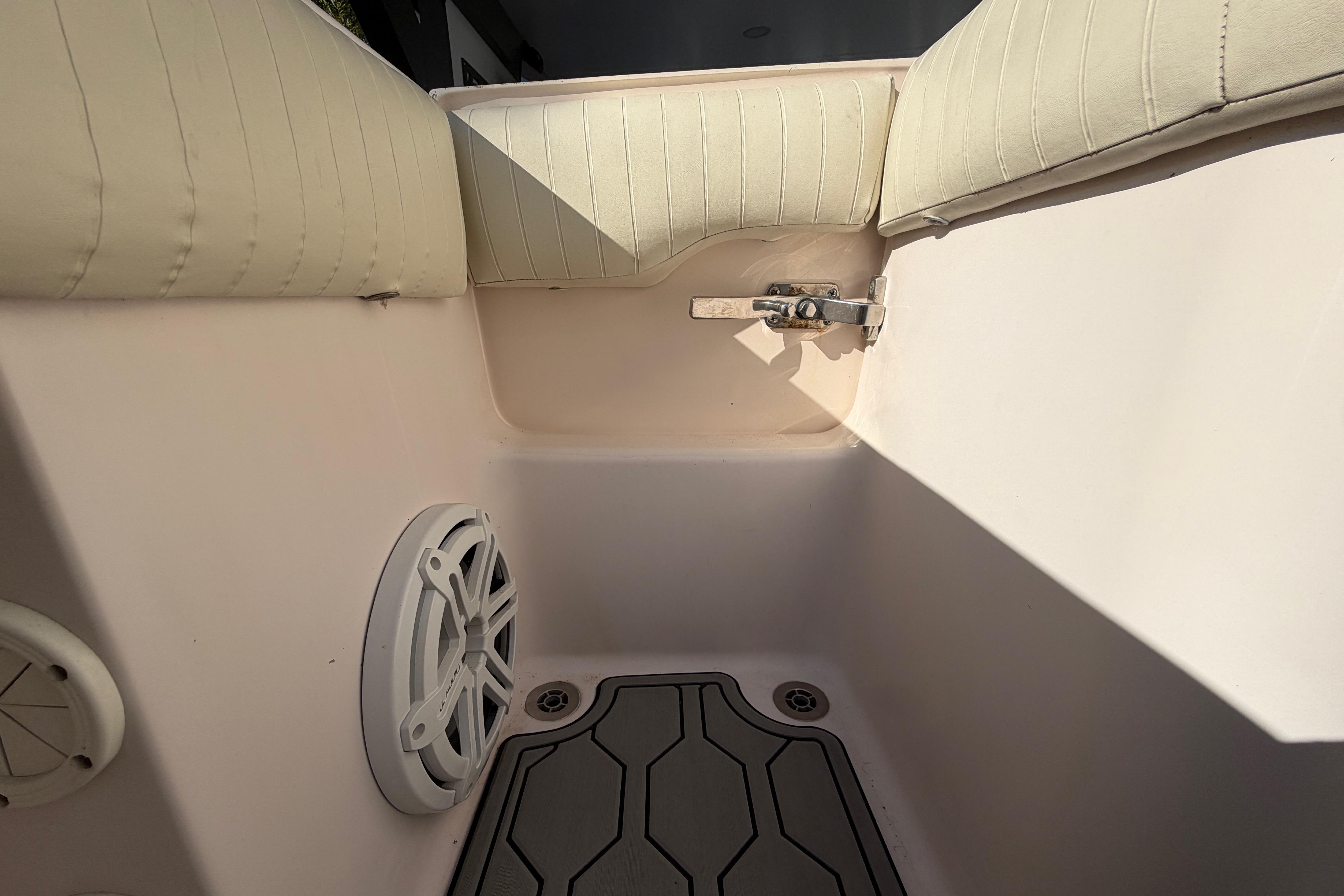Interior of a 2004 Grady White 273 boat, featuring cushioned seating and speaker.