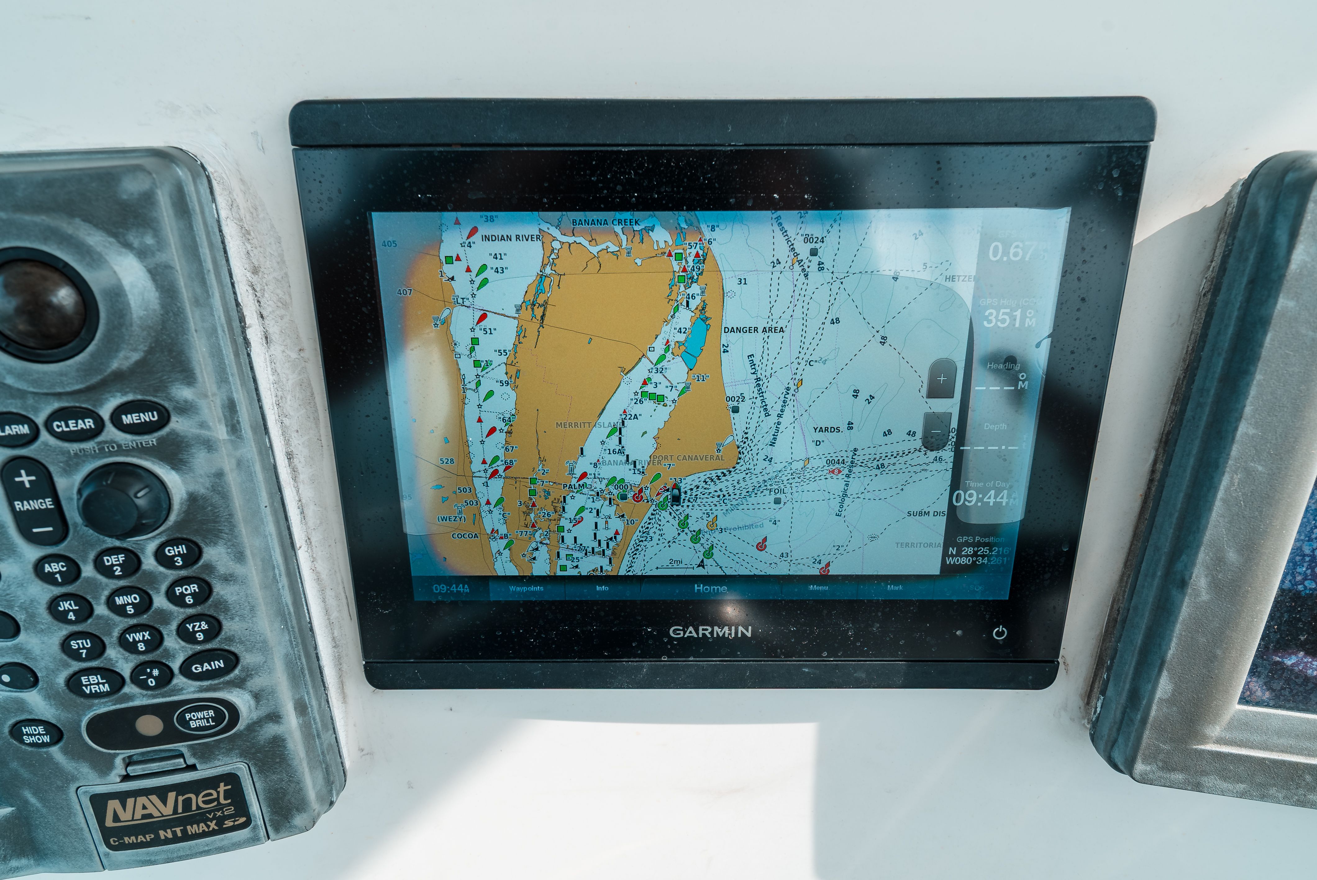 Navigation system on a boat with map display and control buttons.