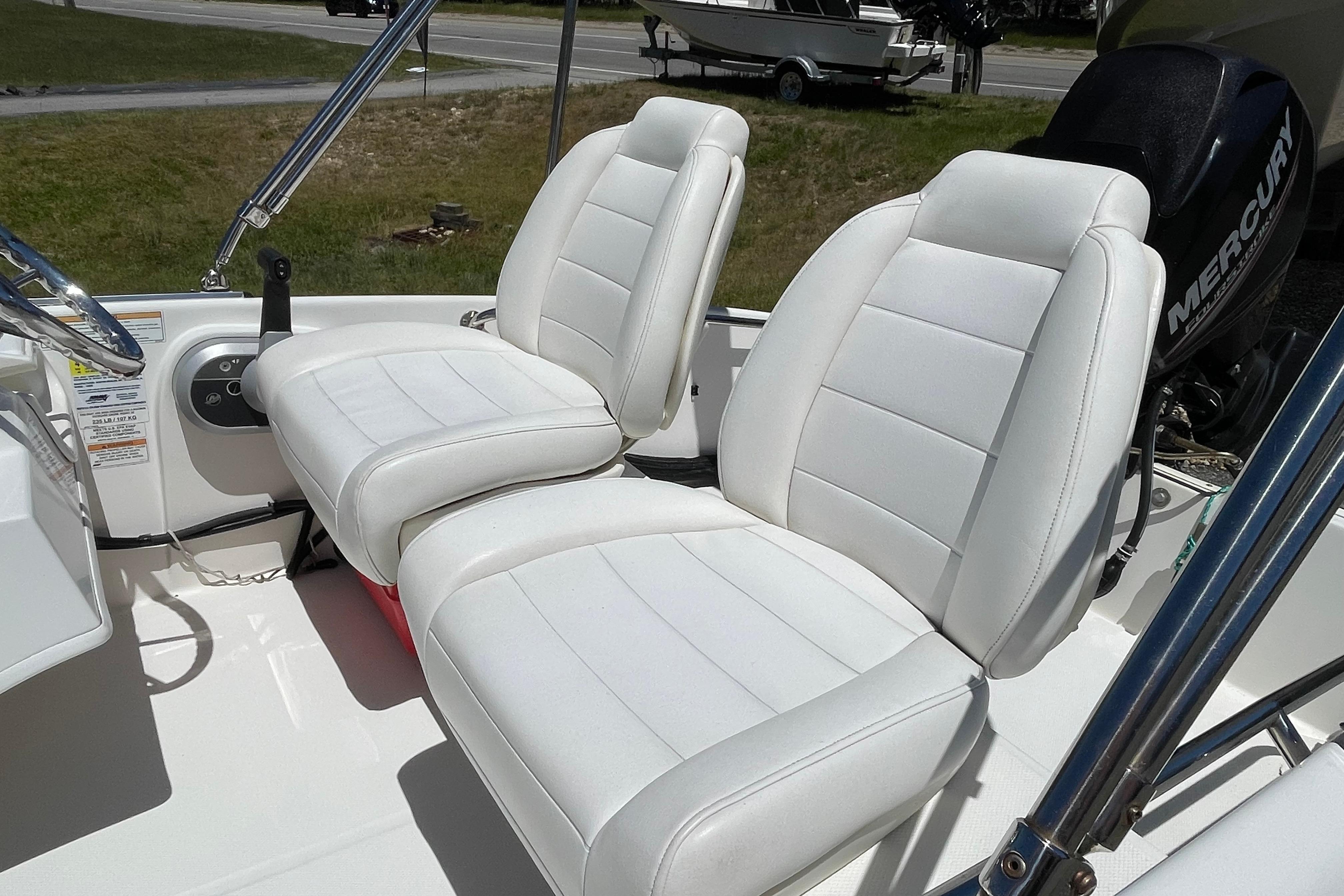 2017 Boston Whaler 130 Super Sport boat interior with white seats and Mercury engine.
