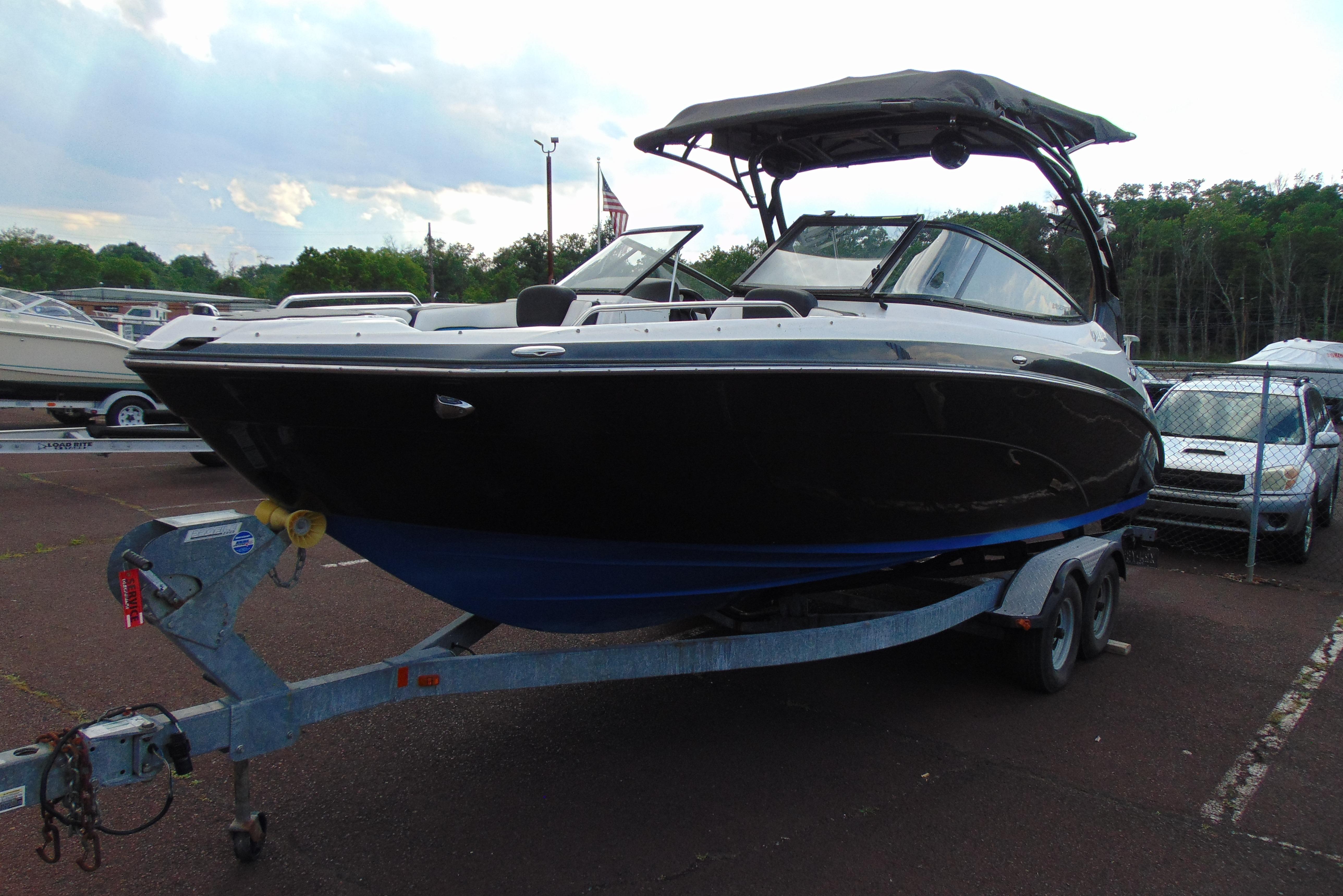 2016 Yamaha Boats 242X E-Series on trailer, parked outdoors with canopy.