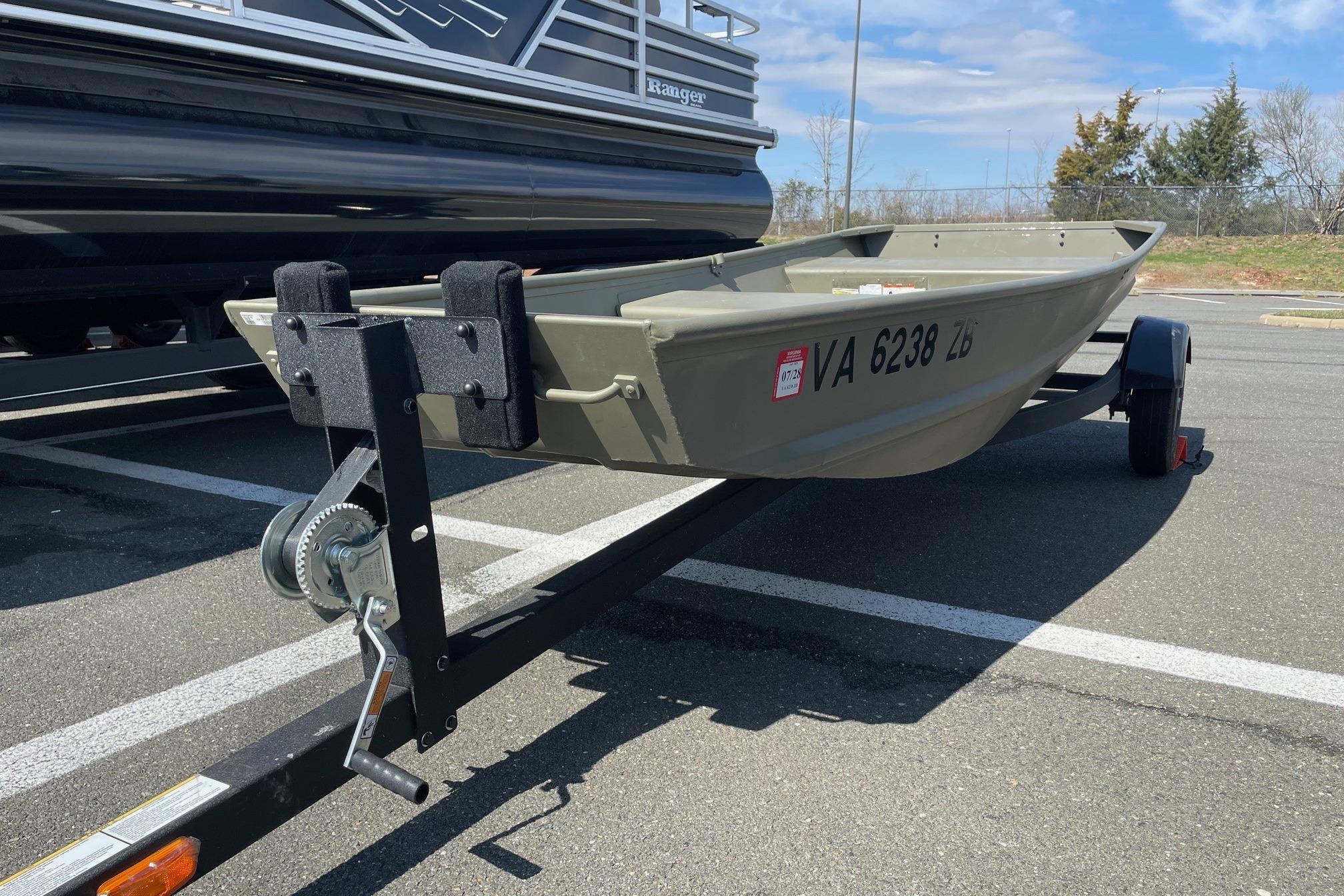 2025 Tracker Grizzly 1236 Jon boat on trailer in parking lot.