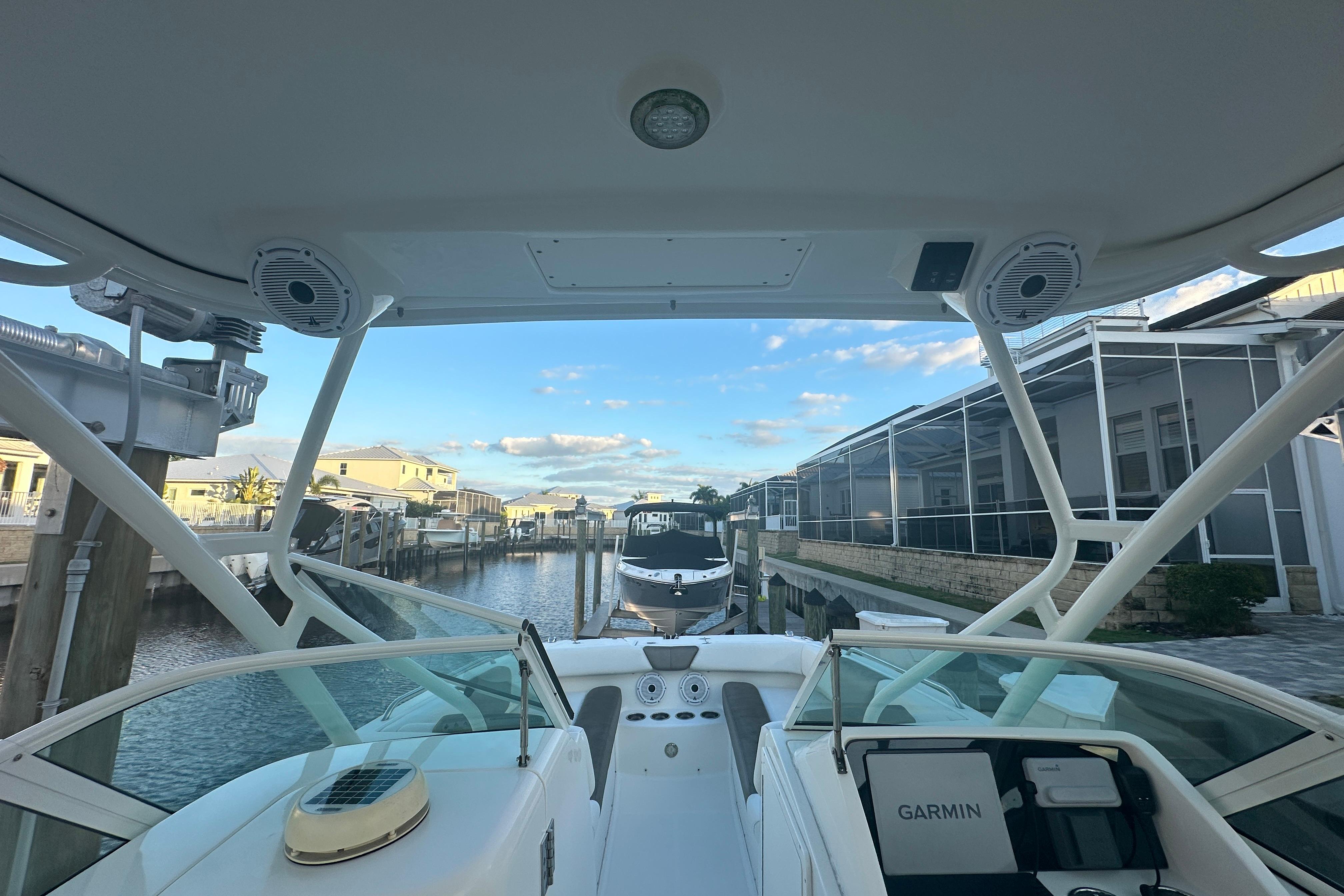 2021 World Cat 230 SD boat docked in a canal with clear blue sky.