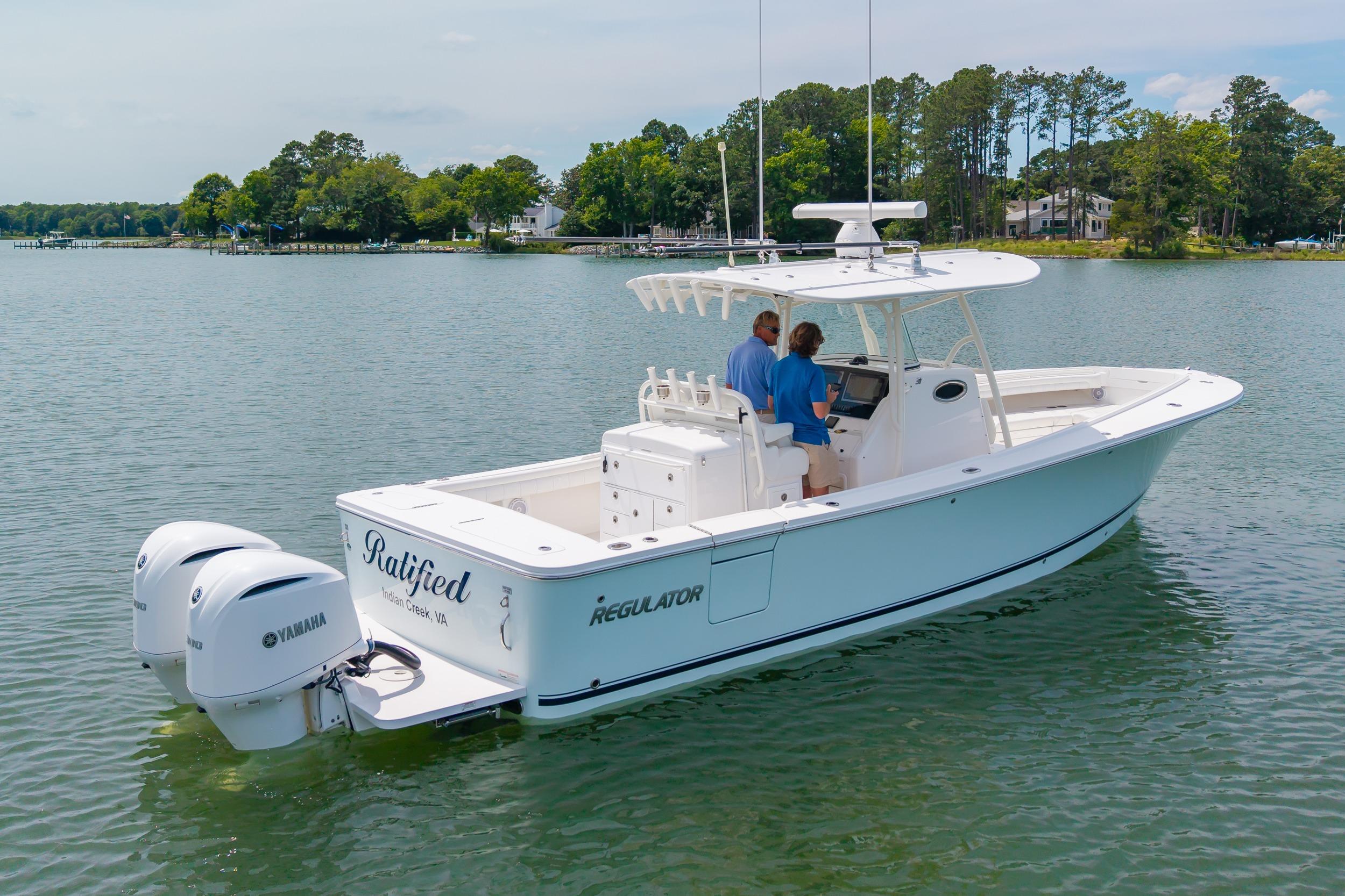 2019 Regulator 31 boat on calm water with two people onboard, featuring twin Yamaha engines.