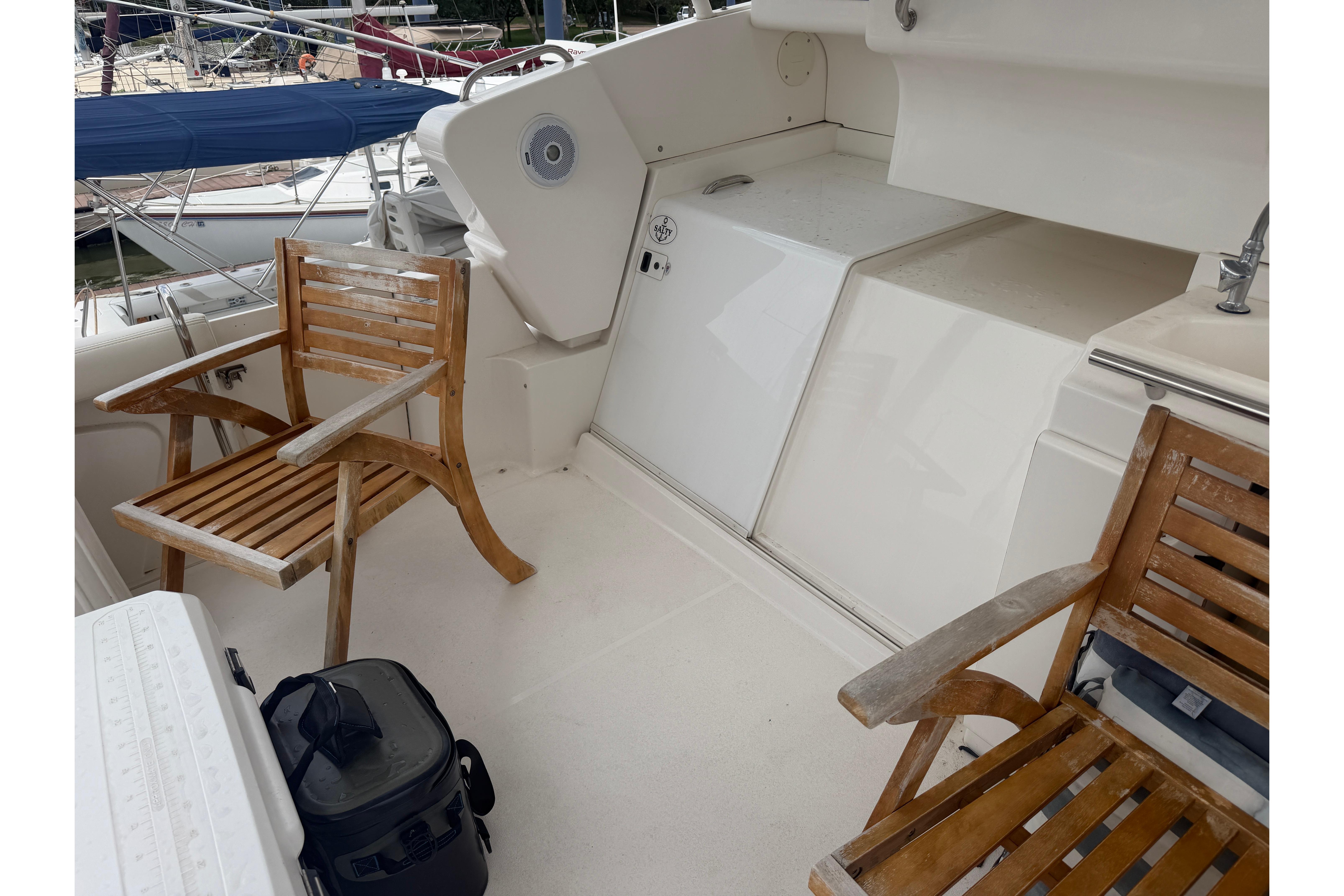 1999 Silverton 352 Motor Yacht deck with wooden chairs and nautical equipment.