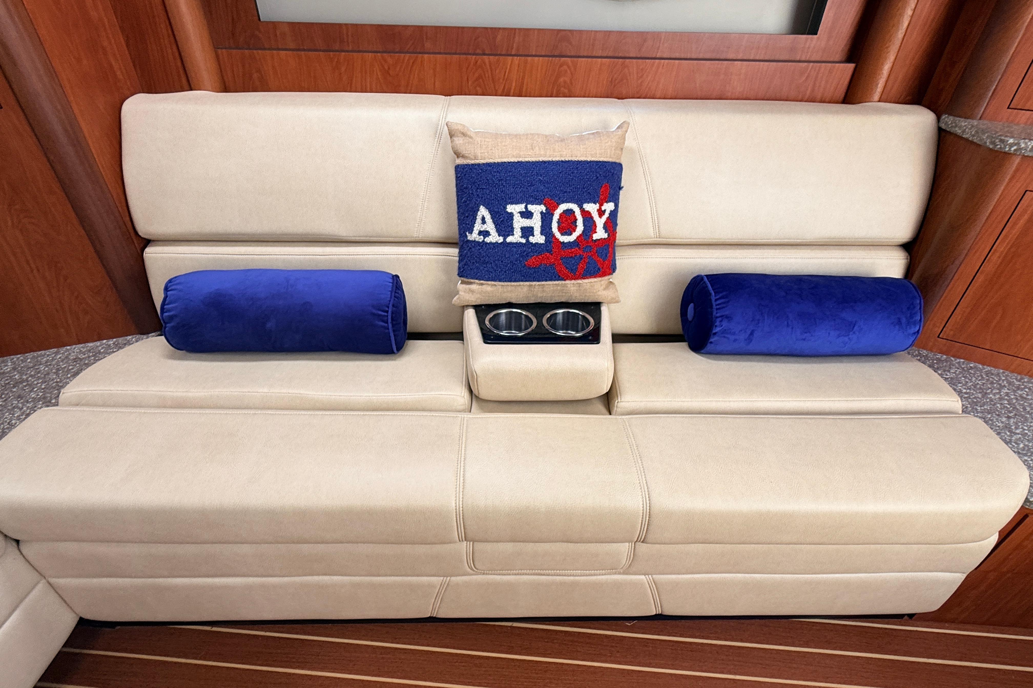 Luxurious beige seating with nautical-themed pillows on a 2011 Monterey 320 Sport Yacht.