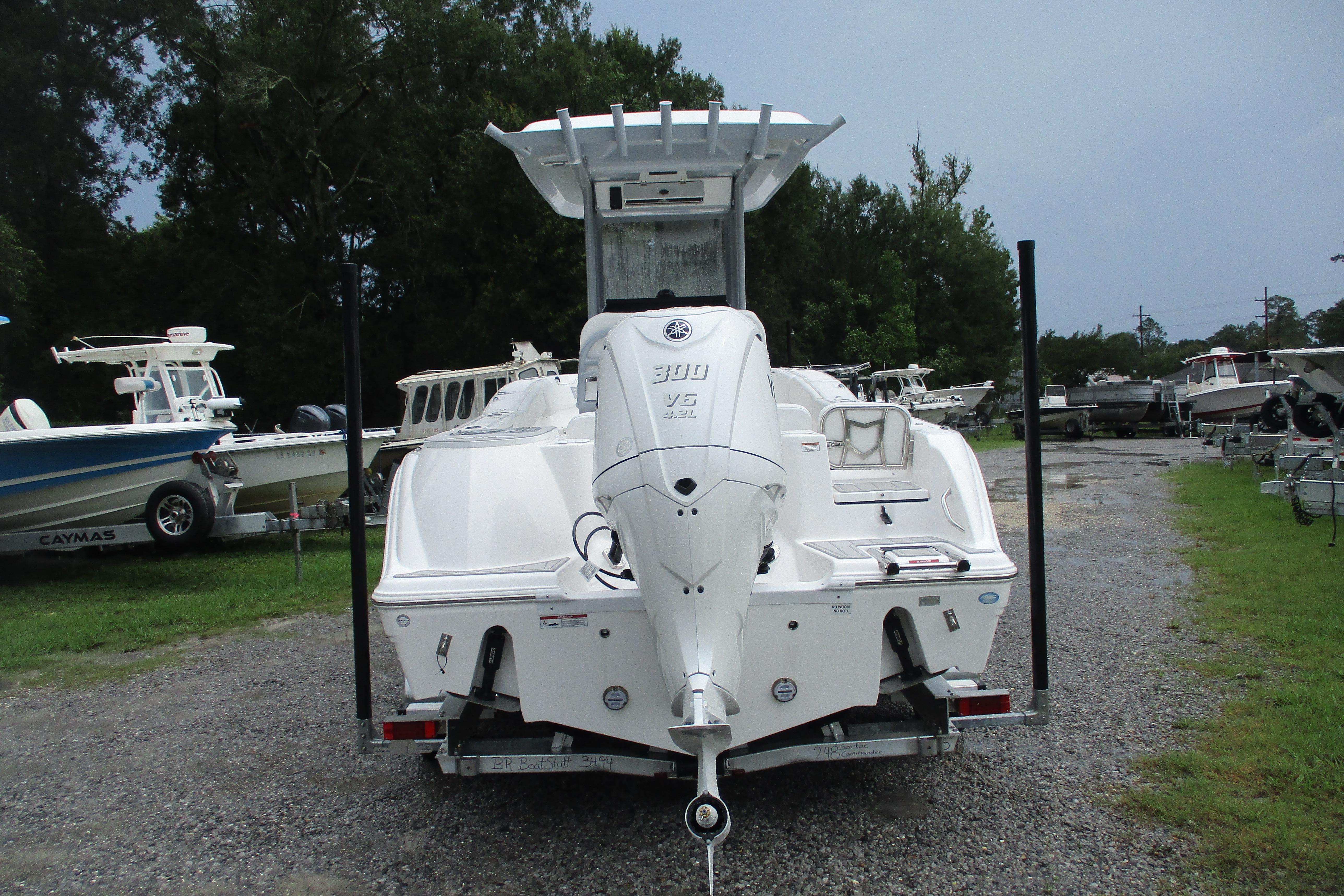2026 Sea Fox 248 Commander boat with powerful outboard motor, parked on gravel lot.