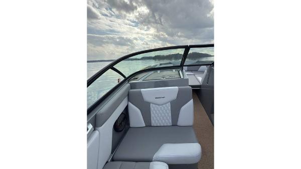 2023 MasterCraft XT22 boat interior with gray seating, lake view, and cloudy sky.