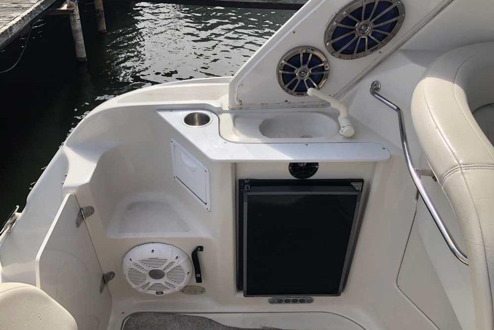 1999 Regal Commodore 2760 boat interior with sink, speakers, and mini fridge.