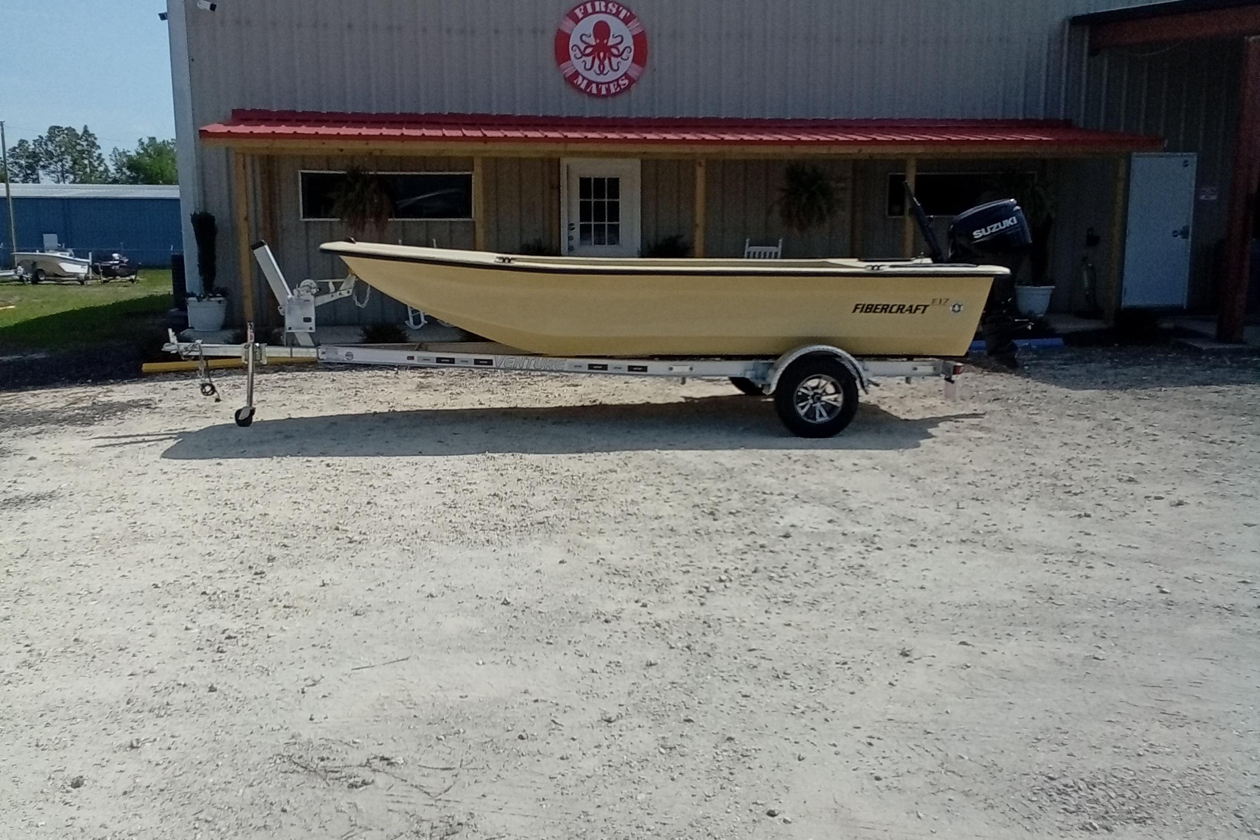 2025 Fibercraft F17 boat on trailer outside a building with red roof.