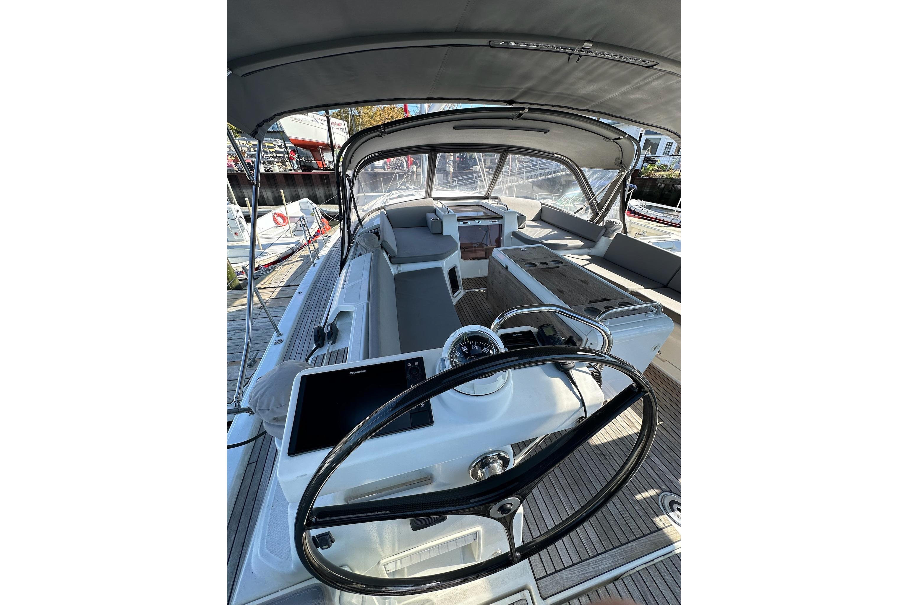 2018 Jeanneau 51 yacht cockpit with steering wheel, navigation equipment, and seating area.