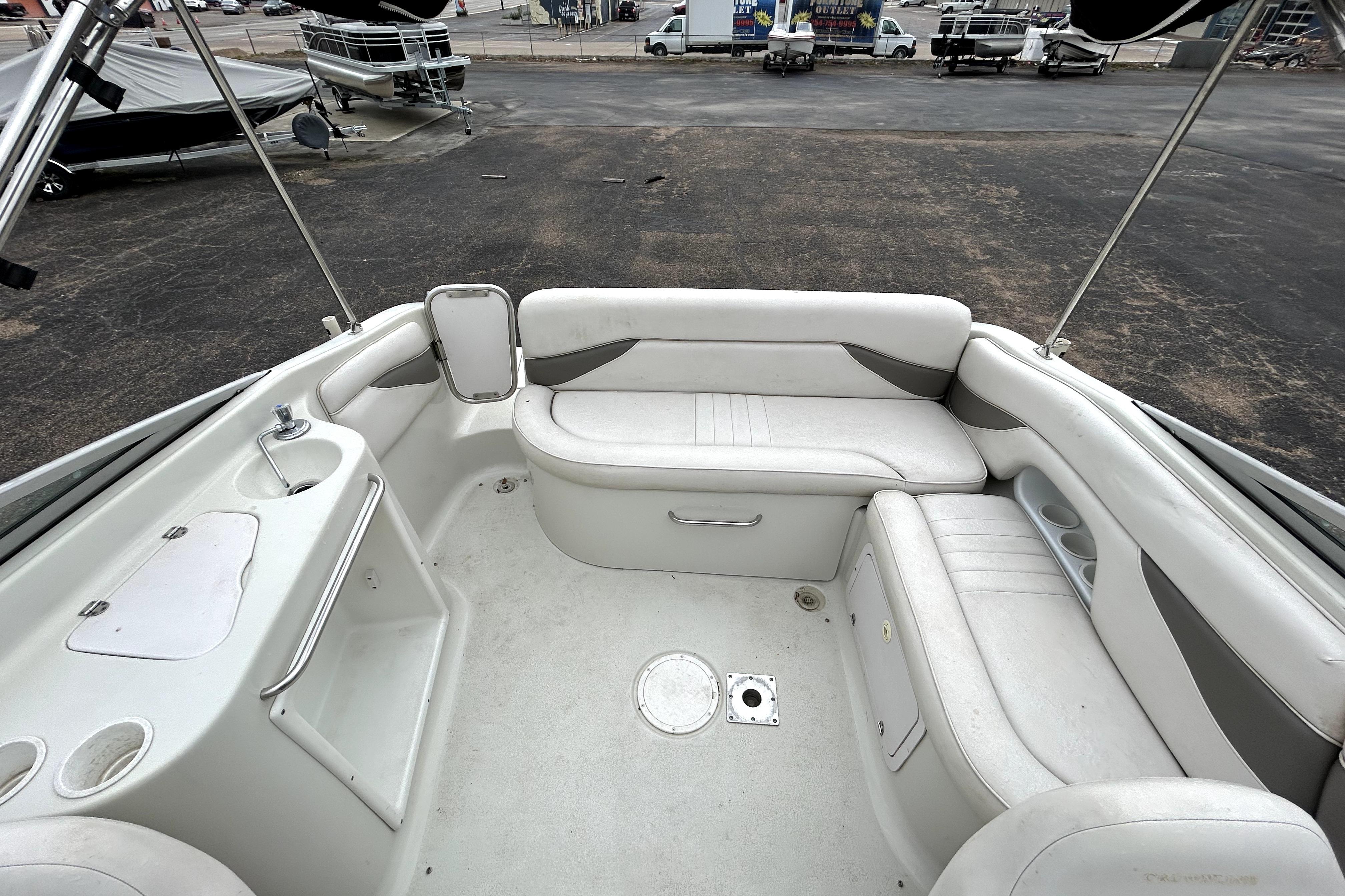 Interior of 2001 Crownline 239 DB boat with white seating and compact sink area.