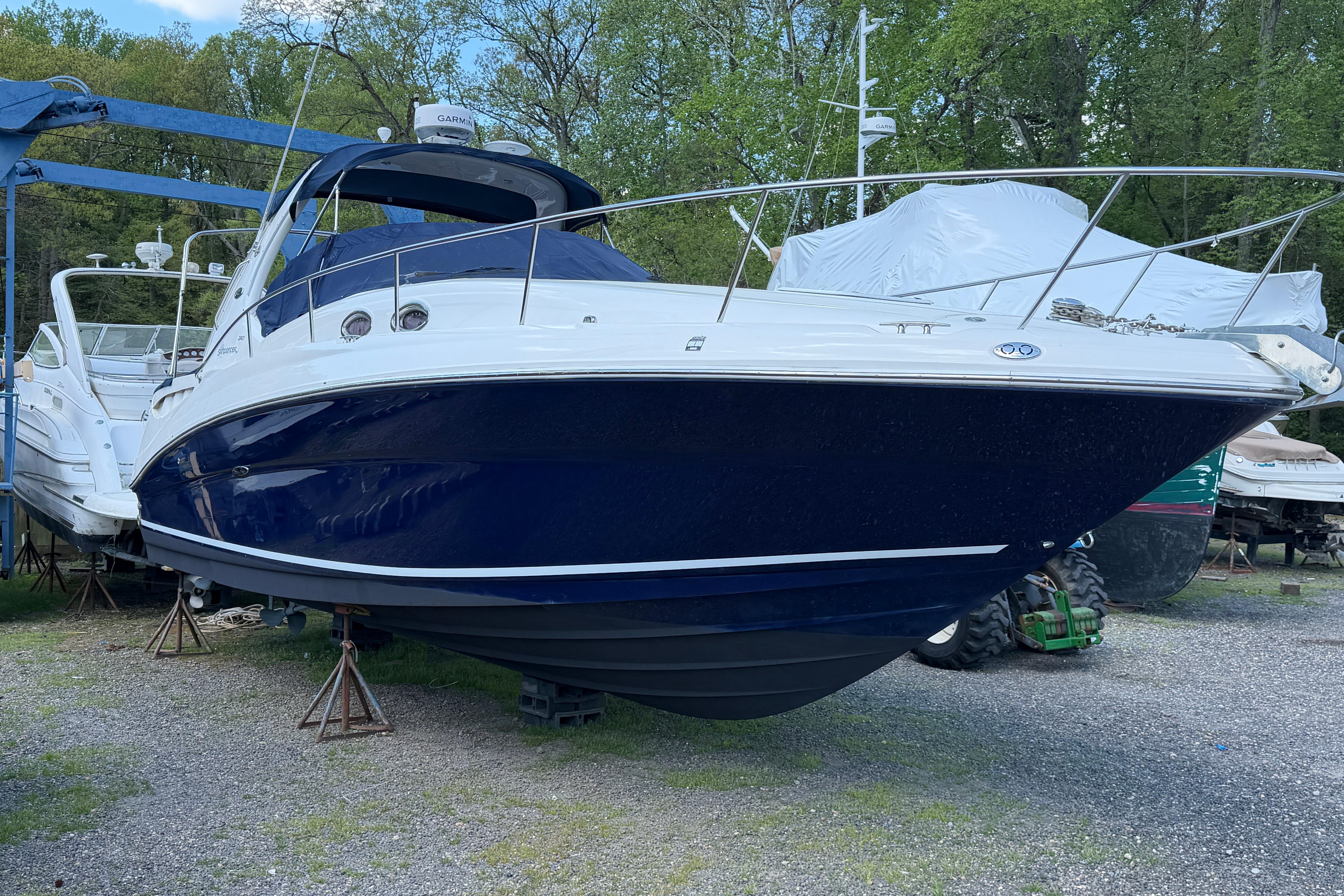 2005 Sea Ray Sundancer 320 boat on stands, surrounded by trees and other boats.