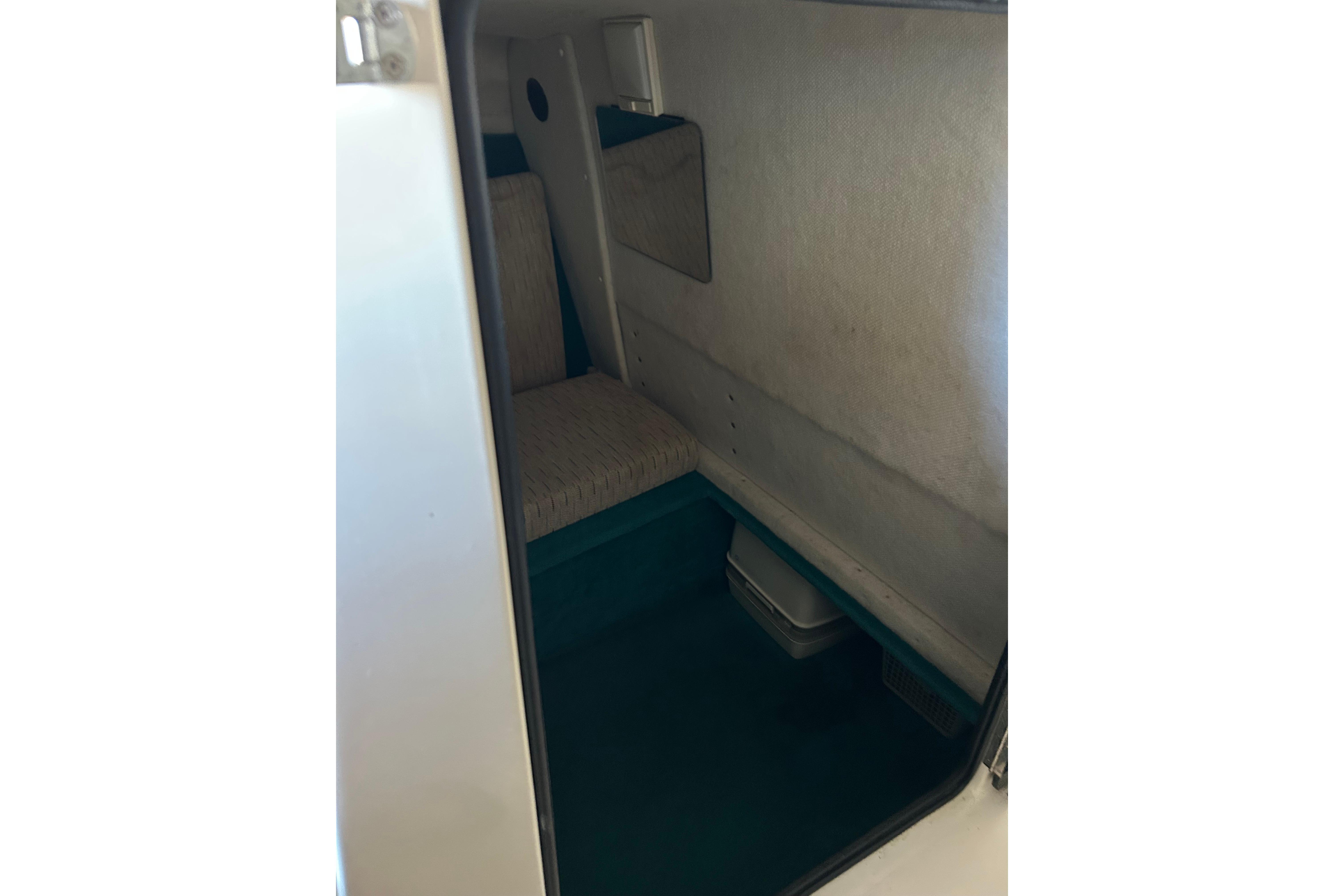 Interior cabin of 1991 Wellcraft 232 Eclipse boat, featuring seating and storage space.