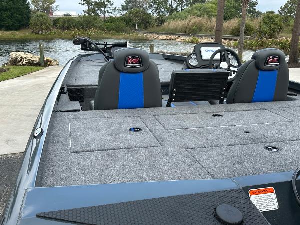 2025 Ranger RT188P boat interior with blue seats, steering wheel, and lake view.