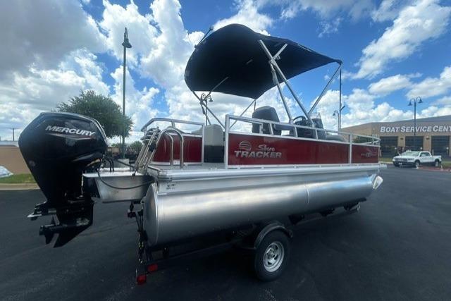 2026 Sun Tracker Bass Buggy 18 DLX pontoon boat with Mercury engine, parked outdoors.