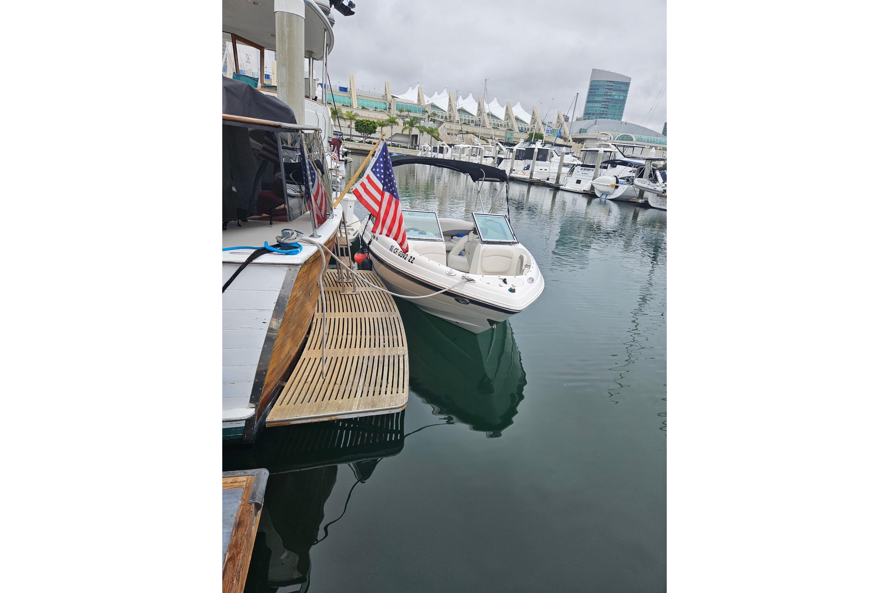 2006 Chaparral 190 SSi boat docked in a marina with American flag.