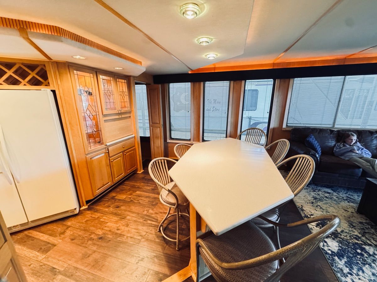 Interior of a 1998 Stardust Cruisers houseboat with dining table and sofa.