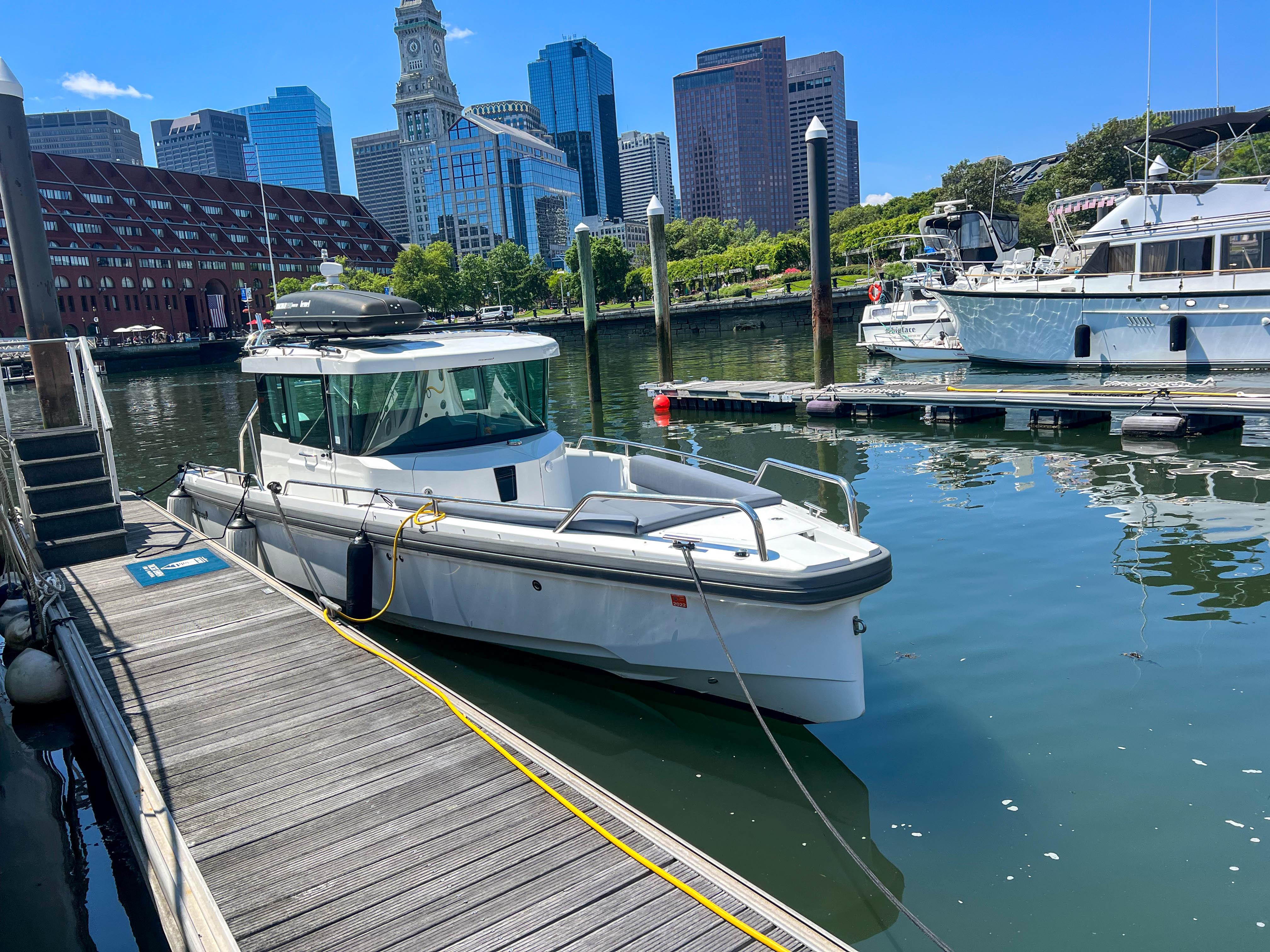 Axopar 28 Cabin 2020 docked at a city marina.