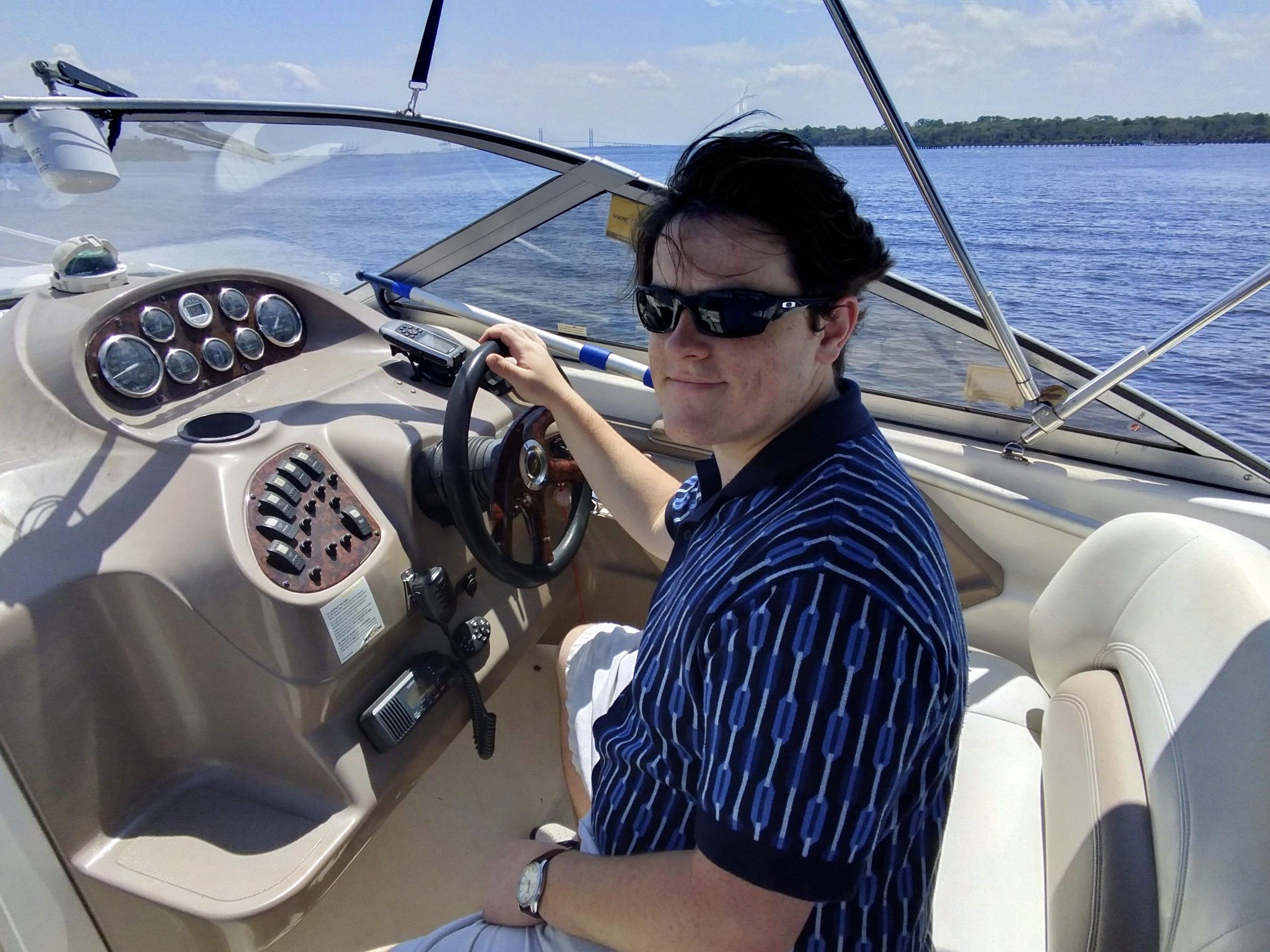 Person steering 2004 Regal Commodore 2465 on open water.