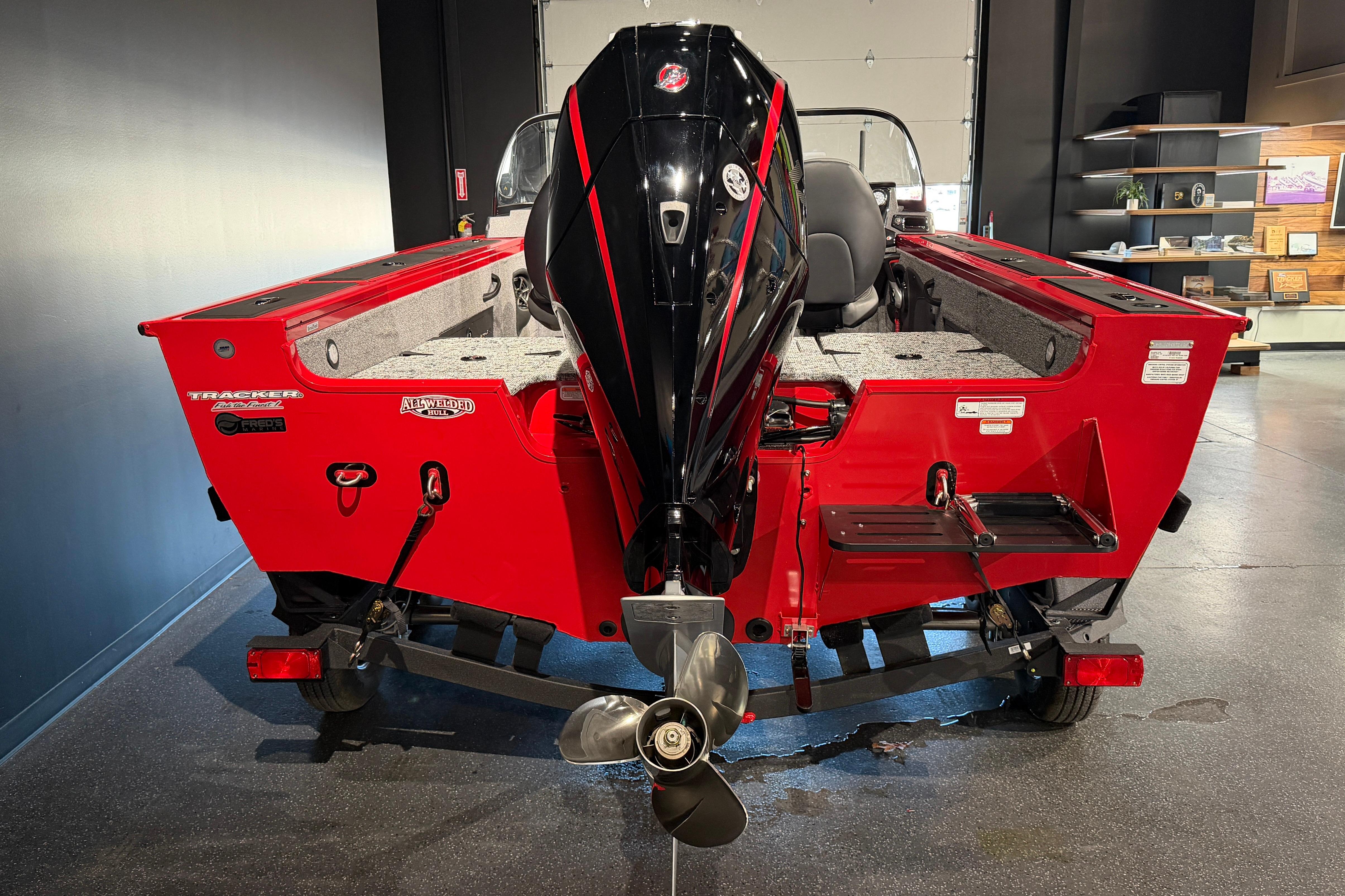 2026 Tracker Targa V-18 Combo boat, rear view, red exterior, displayed indoors.