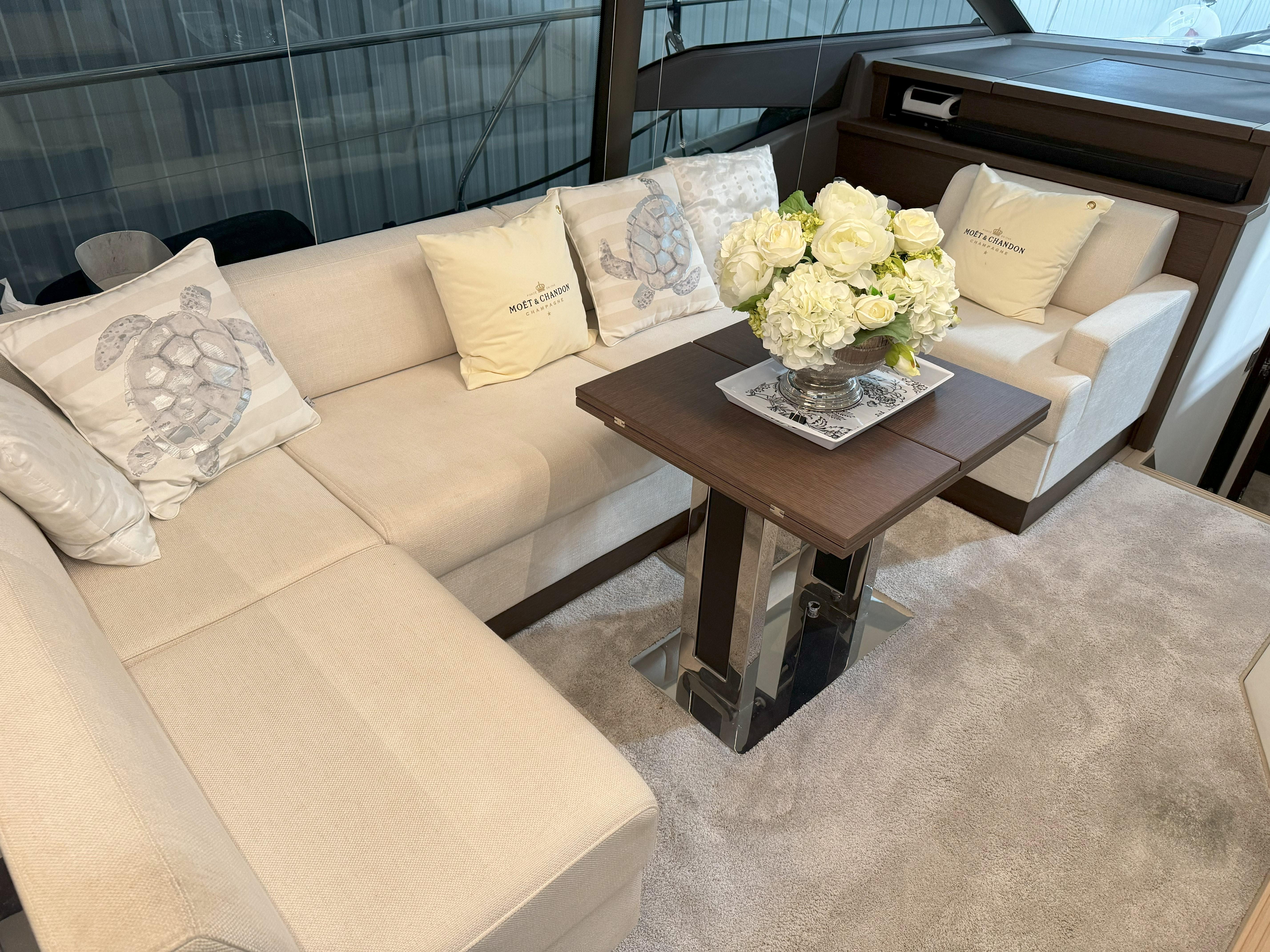 Luxurious interior of 2018 Prestige 520 Fly yacht with elegant seating and floral centerpiece.