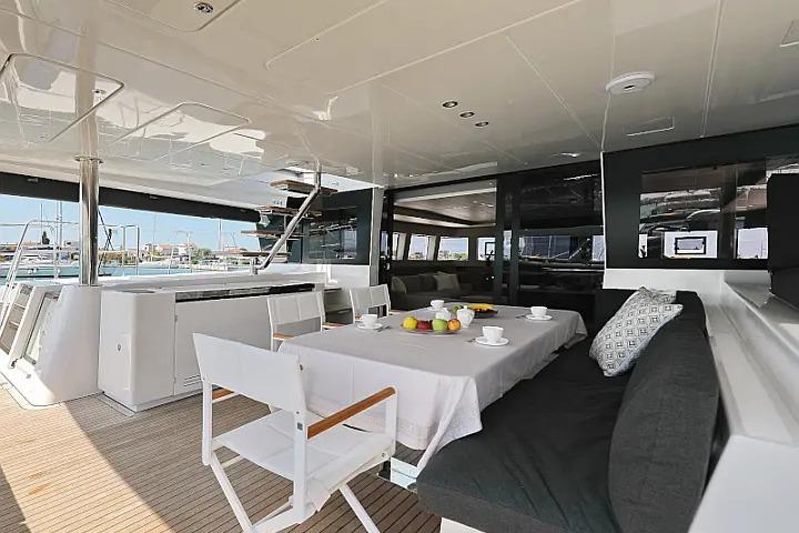 Luxurious Lagoon 620 Esense 2018 yacht interior with dining area and modern furnishings.