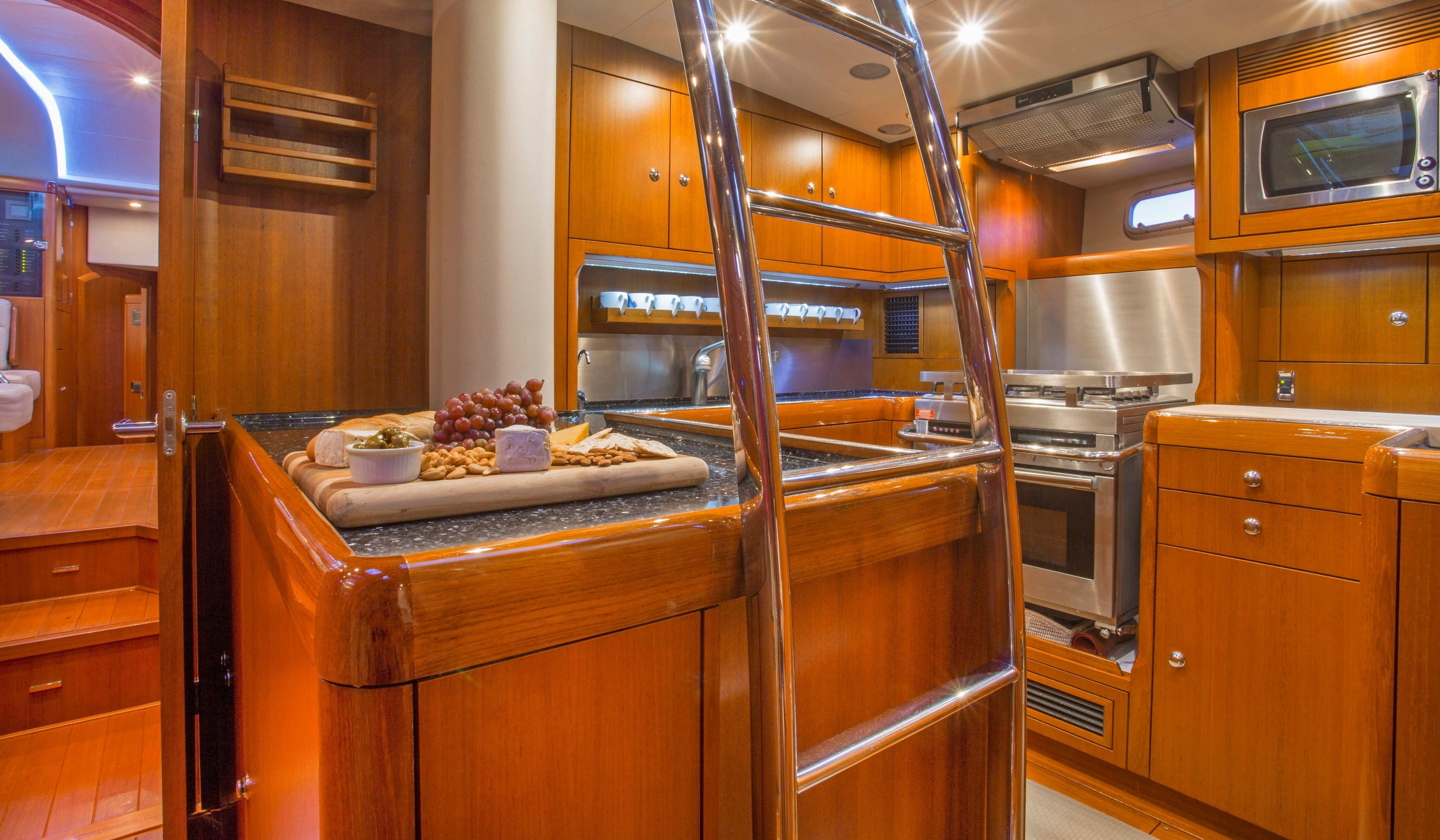Luxurious 2009 Oyster 72 yacht kitchen with wooden cabinetry and modern appliances.