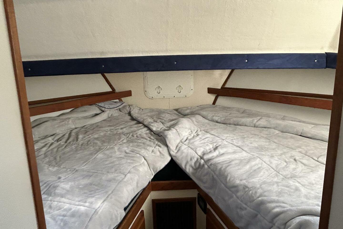 Cozy cabin interior of a 1997 Rosborough Trawler with twin beds and wooden accents.