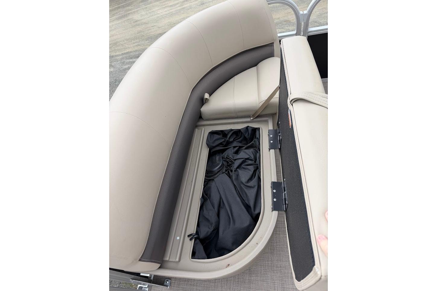 2025 Sun Tracker Party Barge 16 DLX storage compartment with open seat revealing interior space.