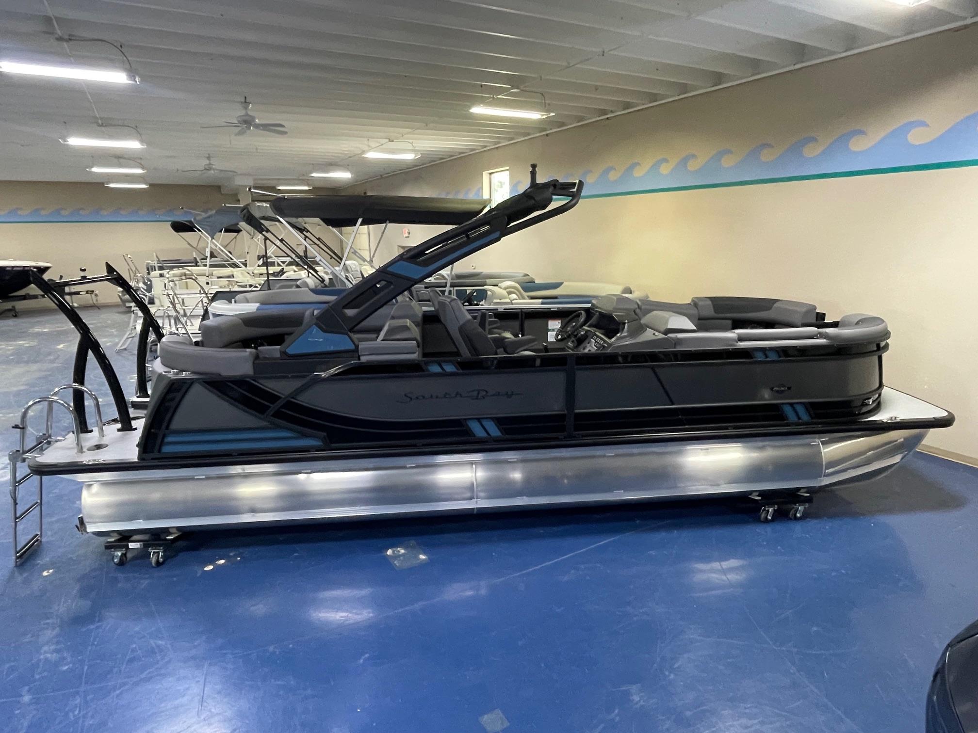 2026 South Bay 525 RS 3.0 Arch pontoon boat in showroom, side view.