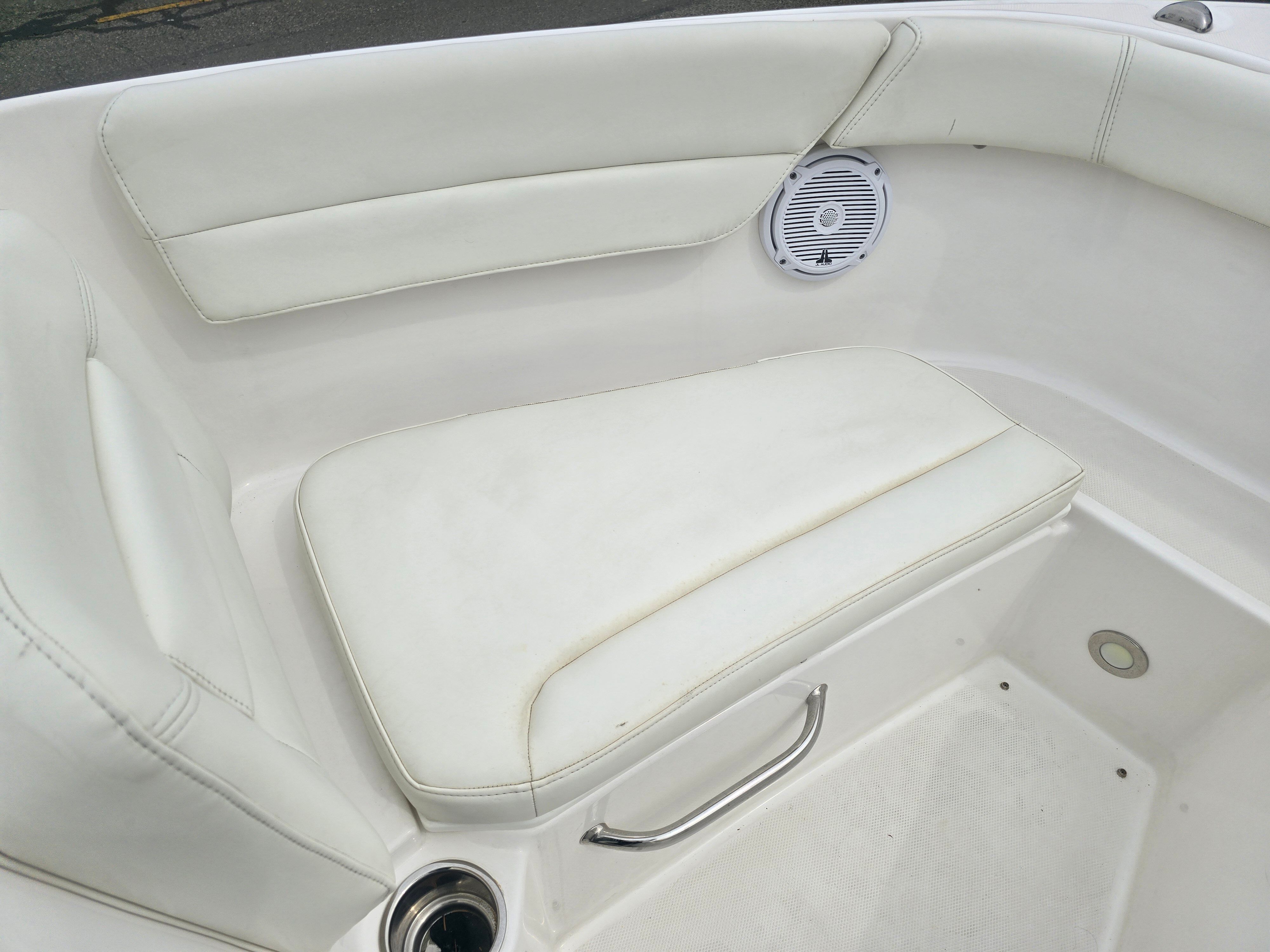 Everglades 230 Dual Console 2017: White cushioned seating with speaker and stainless steel handle.