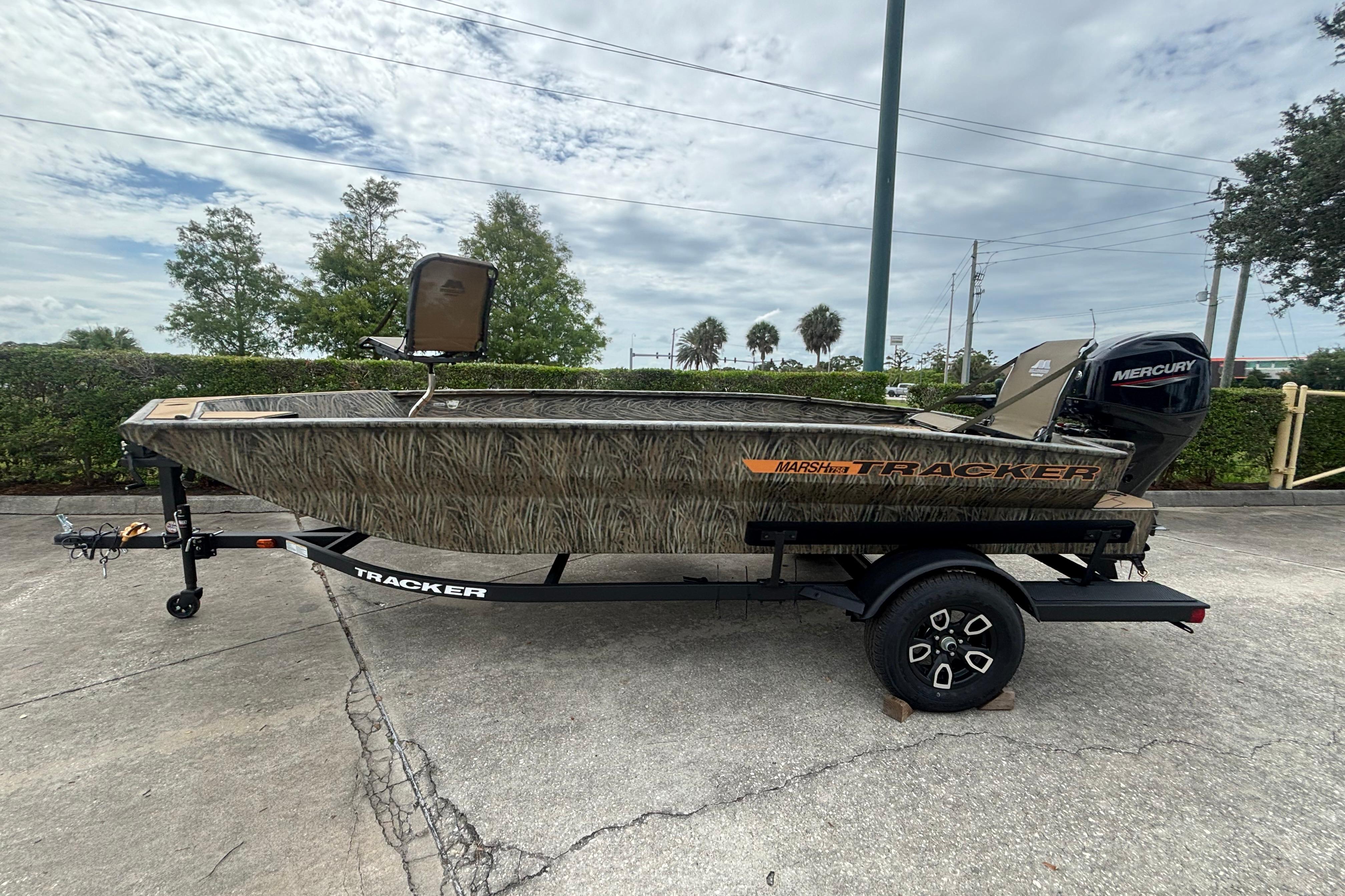 2026 Tracker Grizzly 1756 T Marsh boat on trailer, camo design, parked outdoors.