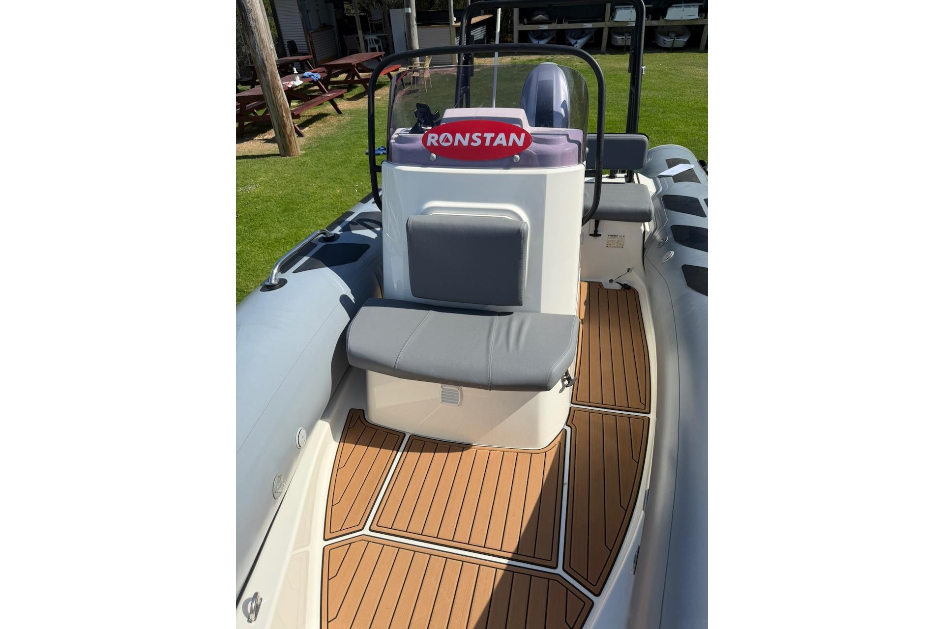 2022 Brig Navigator 485 boat interior with cushioned seating and wooden deck flooring.