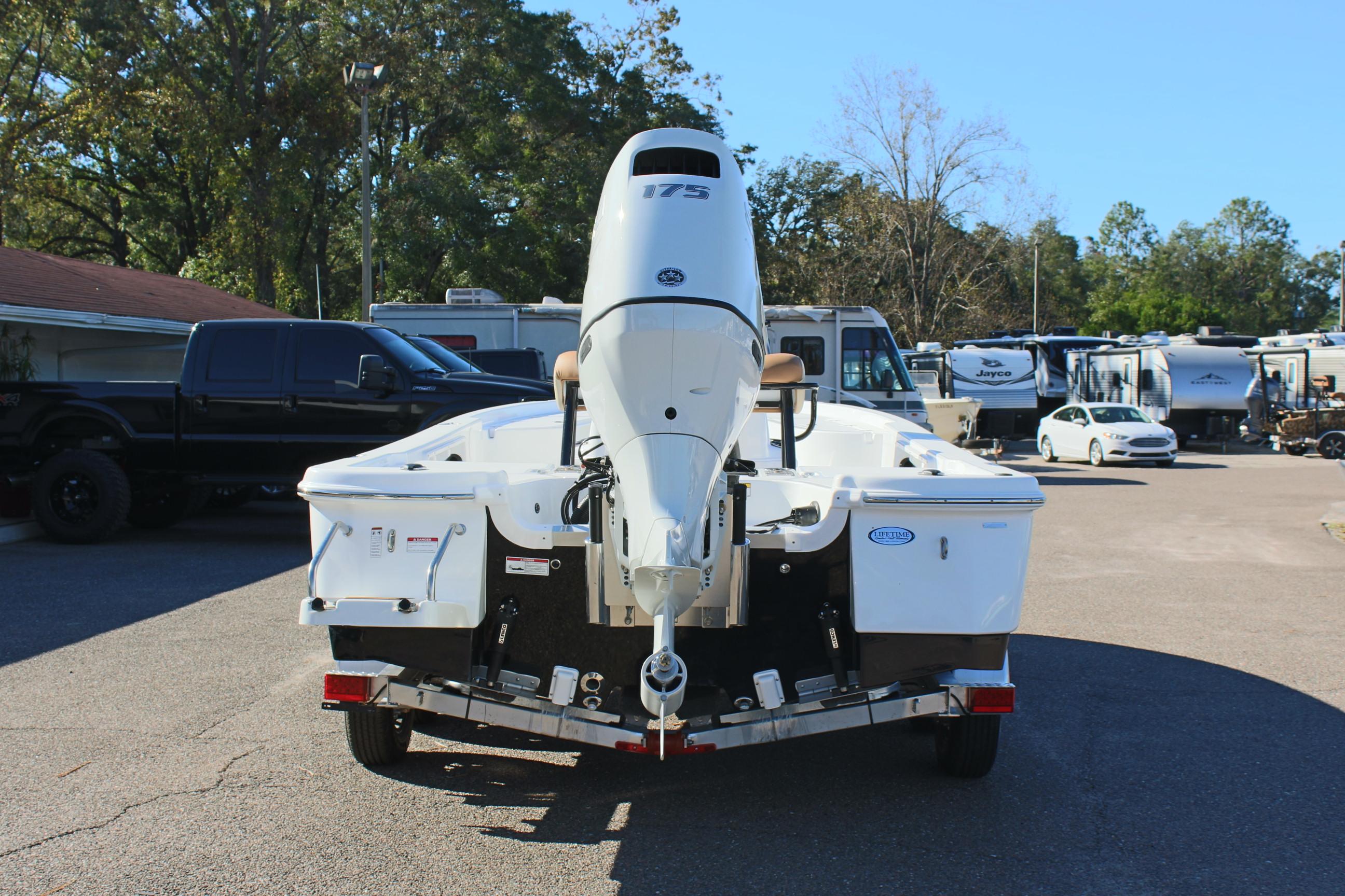 2025 NauticStar 214 Shallow Bay boat on trailer, rear view in parking lot.