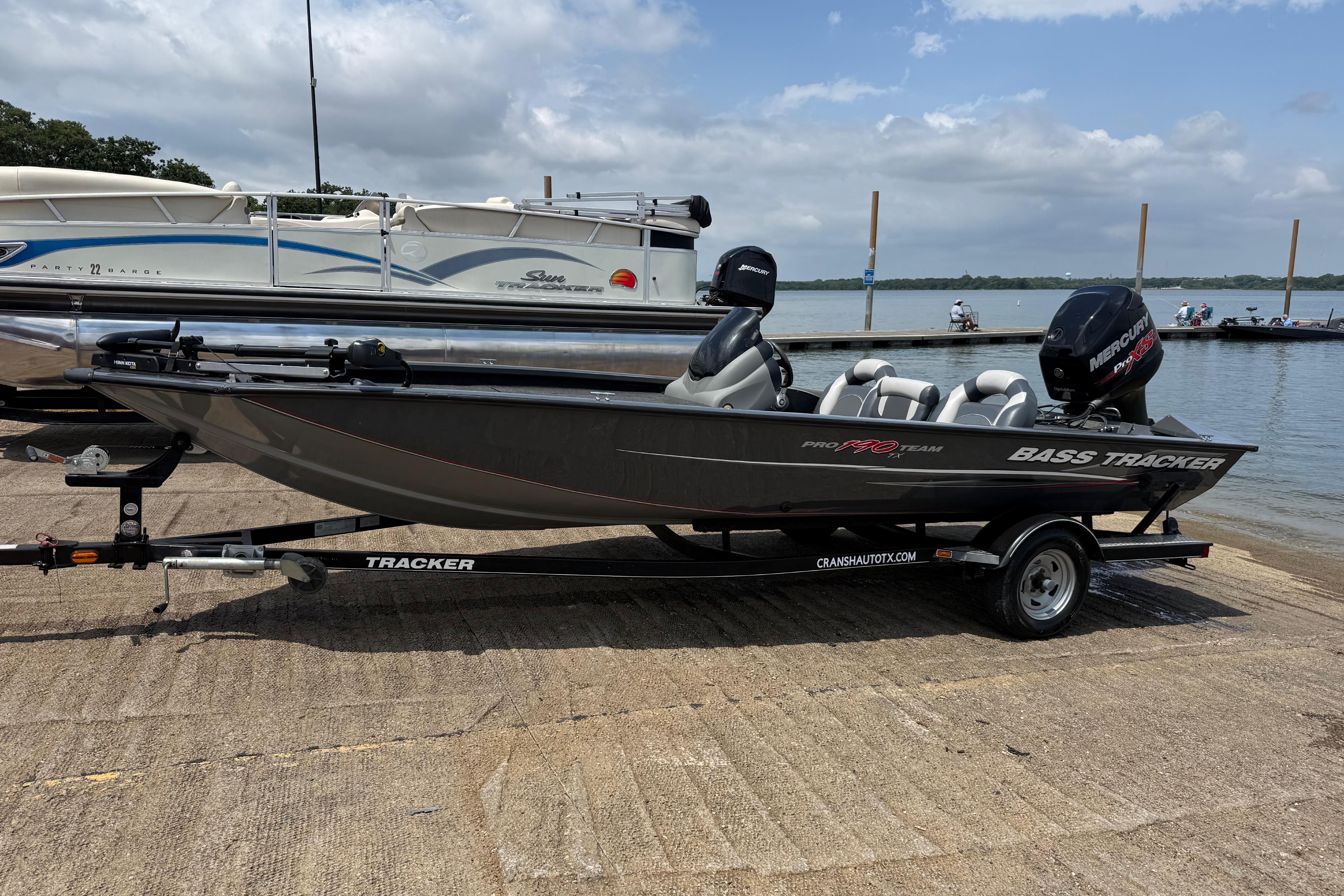 2015 Tracker Pro Team 190 TX bass boat on trailer by a lake.