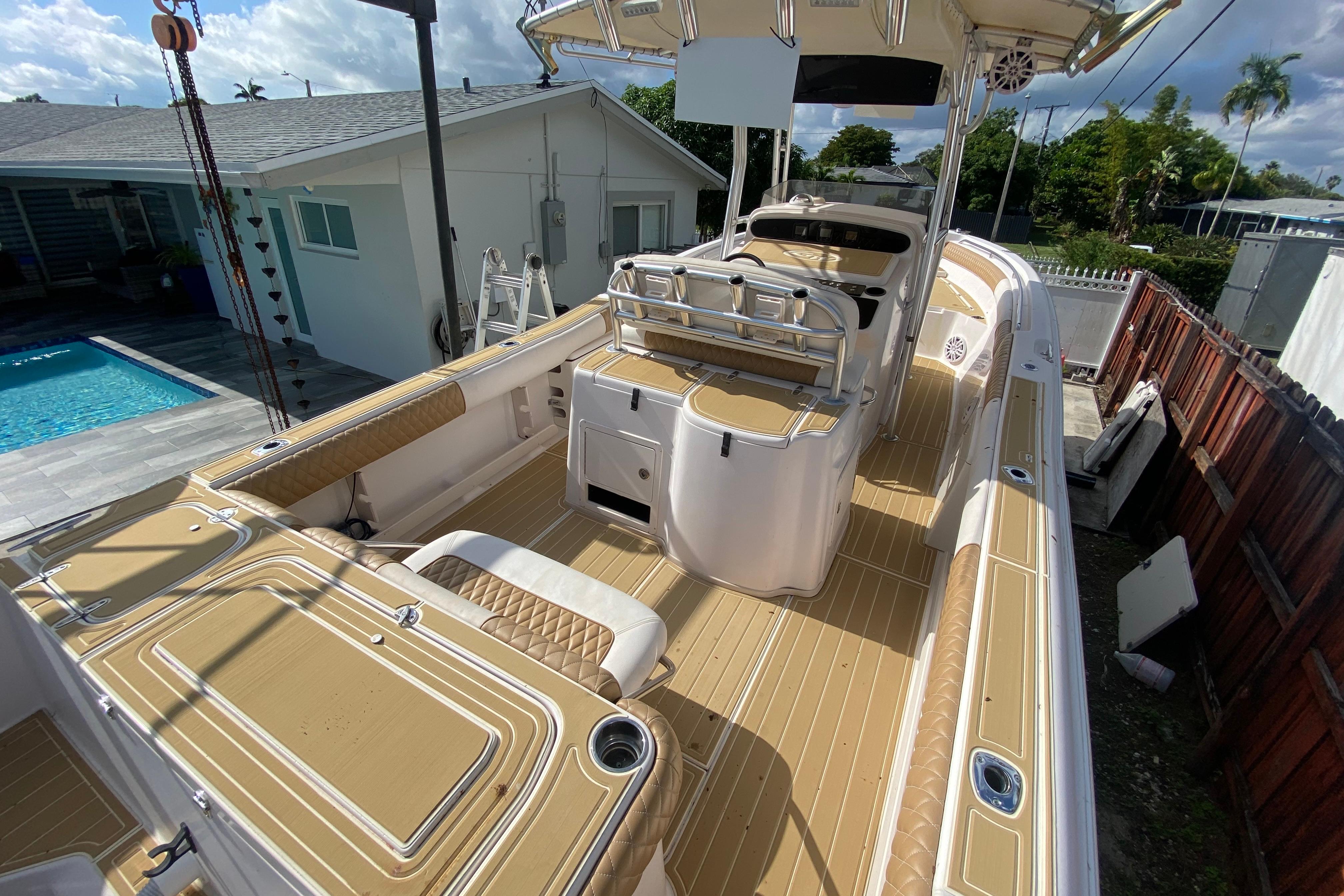 2004 Grady-White Canyon 283 boat with tan deck, near a poolside house.