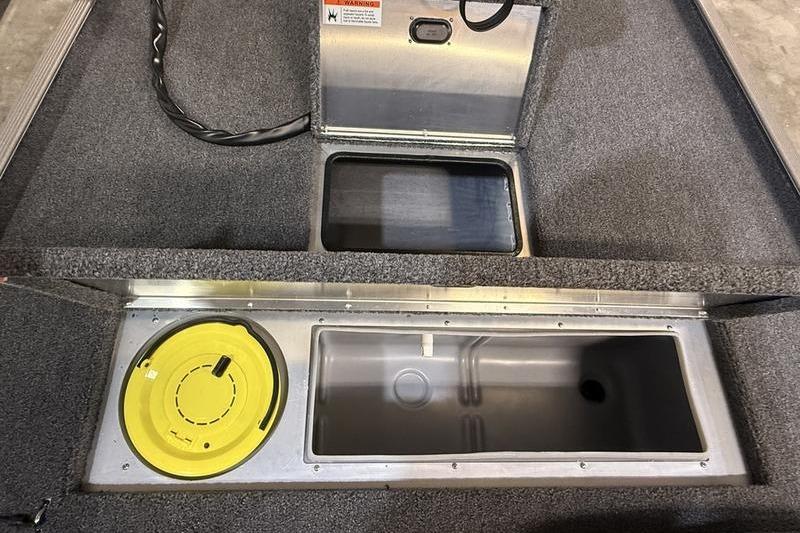 2026 Lowe Skorpion 16 boat storage compartments with yellow lid and carpeted interior.