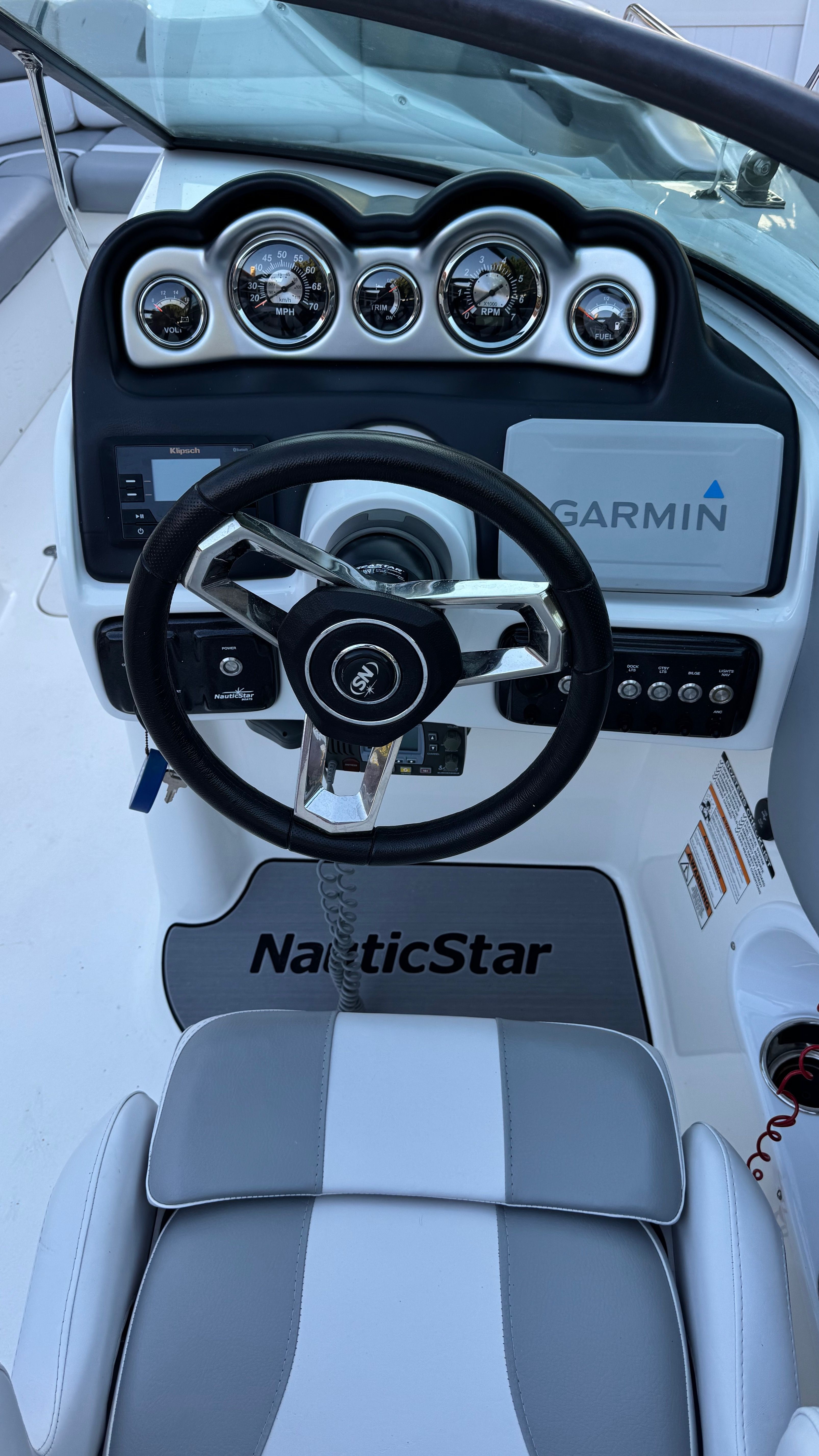 The image shows the helm of a 2022 NauticStar 243 DC boat with Garmin navigation.